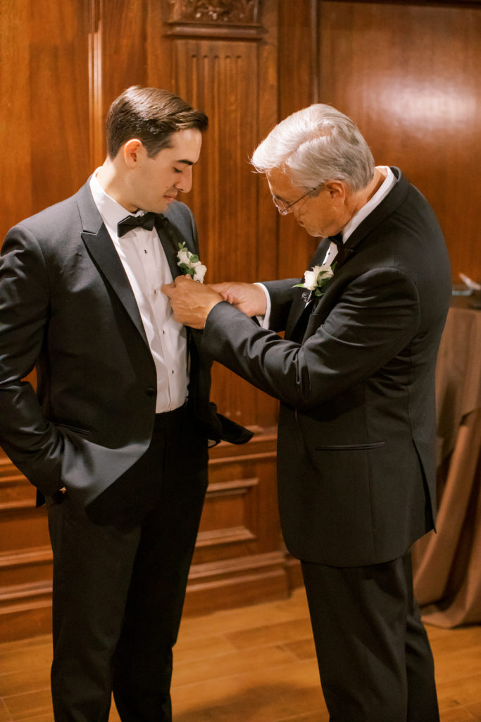 father of the groom puts on groom's boutonniere - Park Savoy Wedding Photography