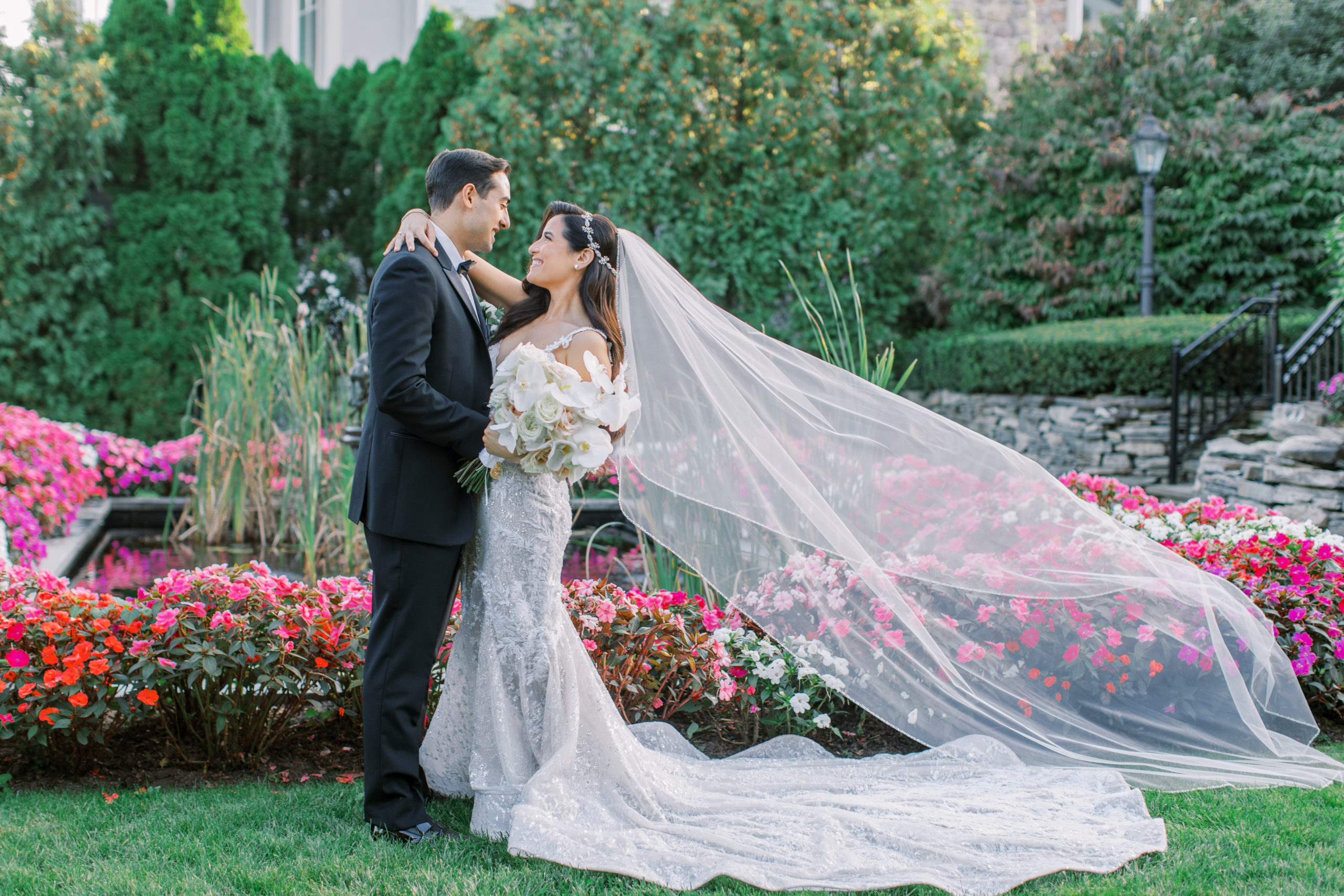 Bride and groom smile in the garden as bride's veil flows behind her - Park Savoy Wedding Photography