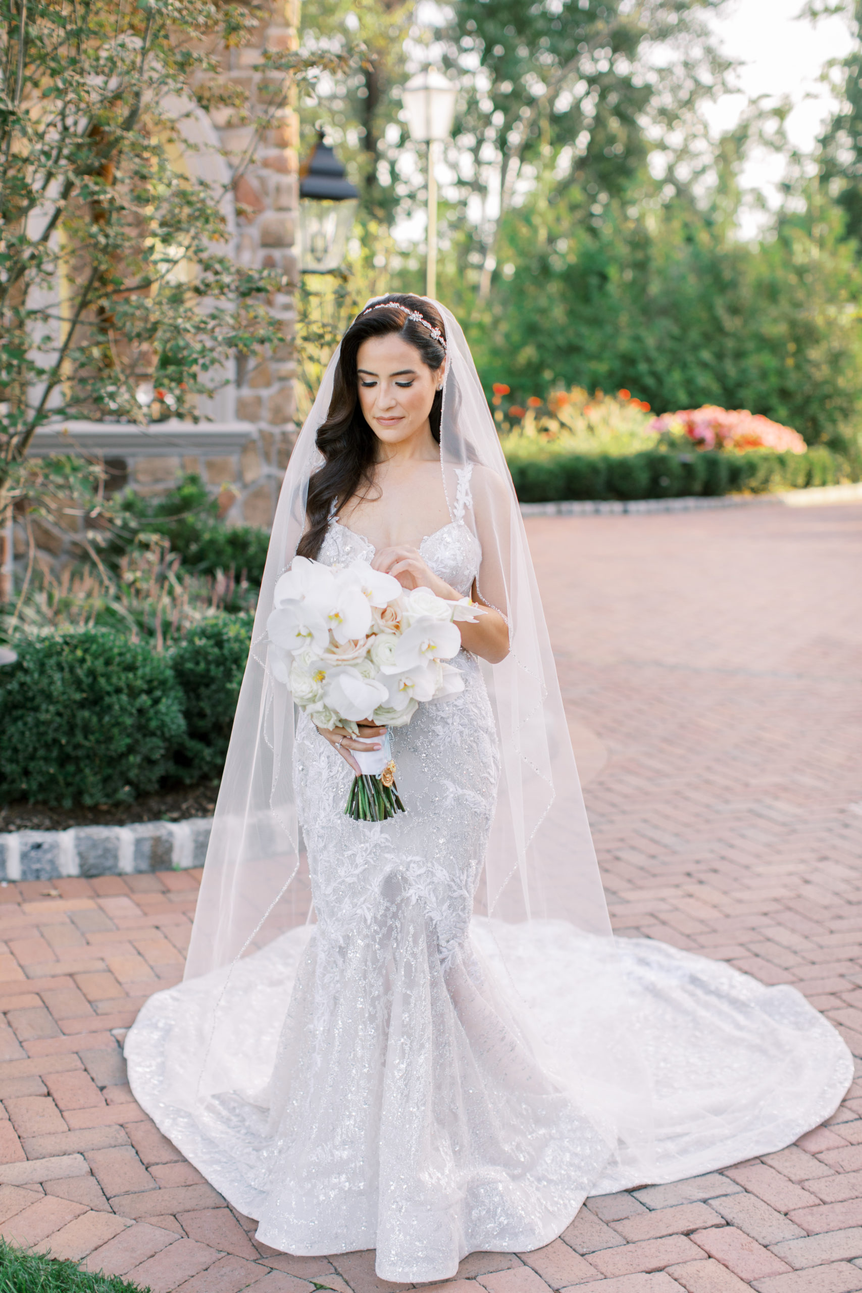 bride in sparkling berta dress looks at flowers - Park Savoy Wedding Photography