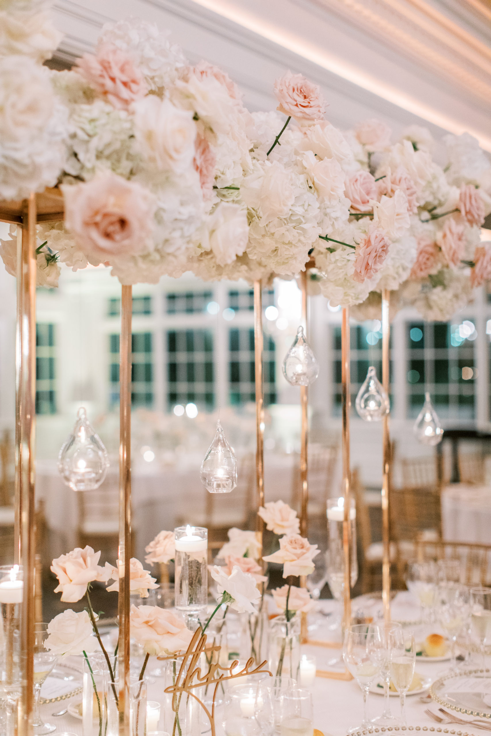 wedding reception table with blush roses white hydrangeas and gold accents