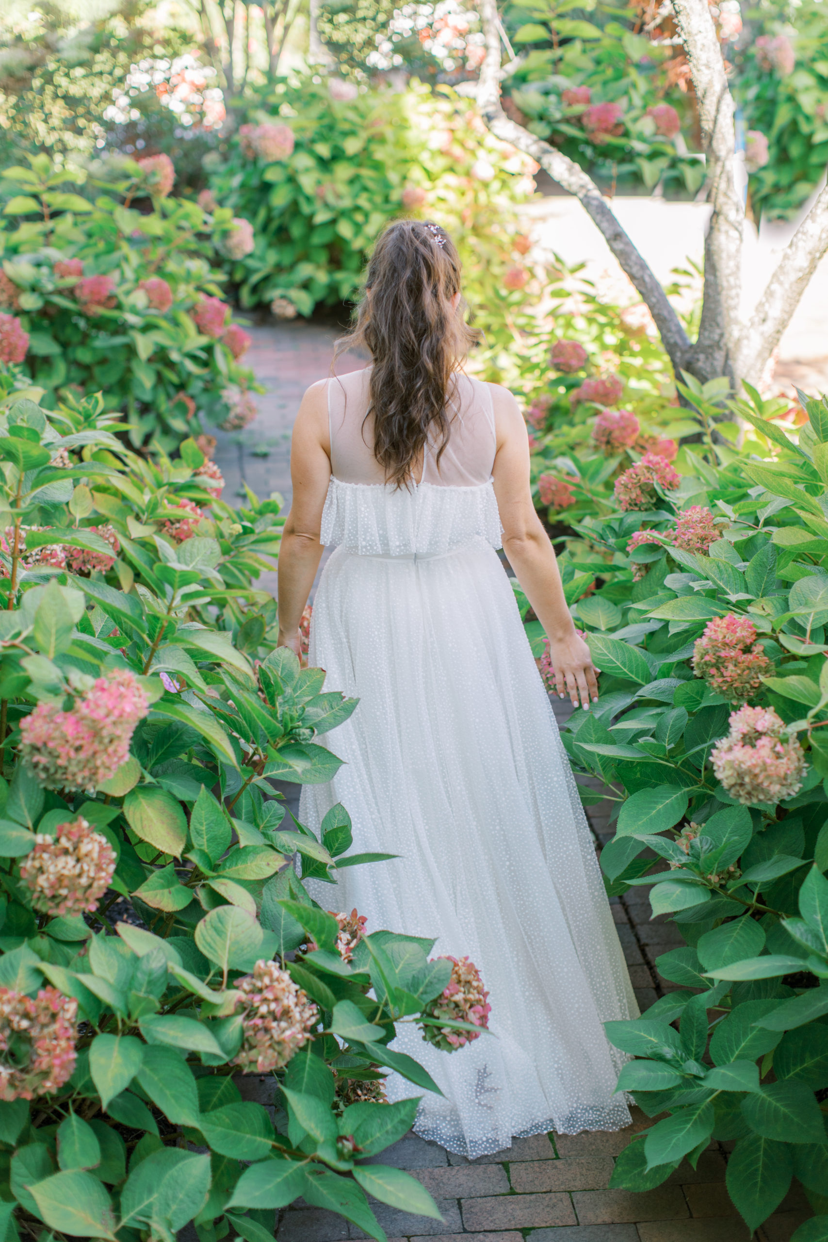 bride in flowing dress walks among hydrangeas NJ Private Estate Wedding Photography