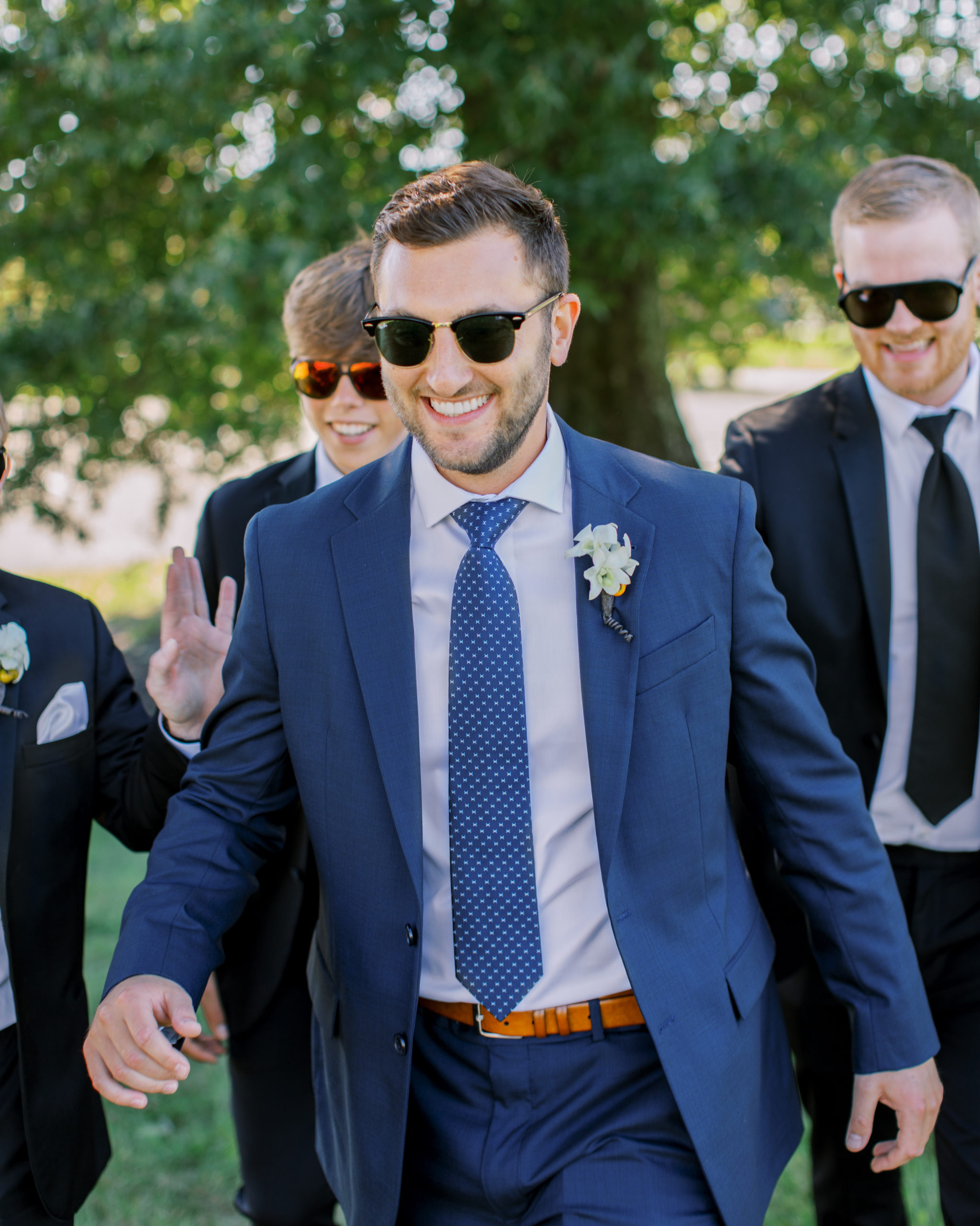 groom in blue suit laughs as he walks with groomsmen NJ Private Estate Wedding Photography