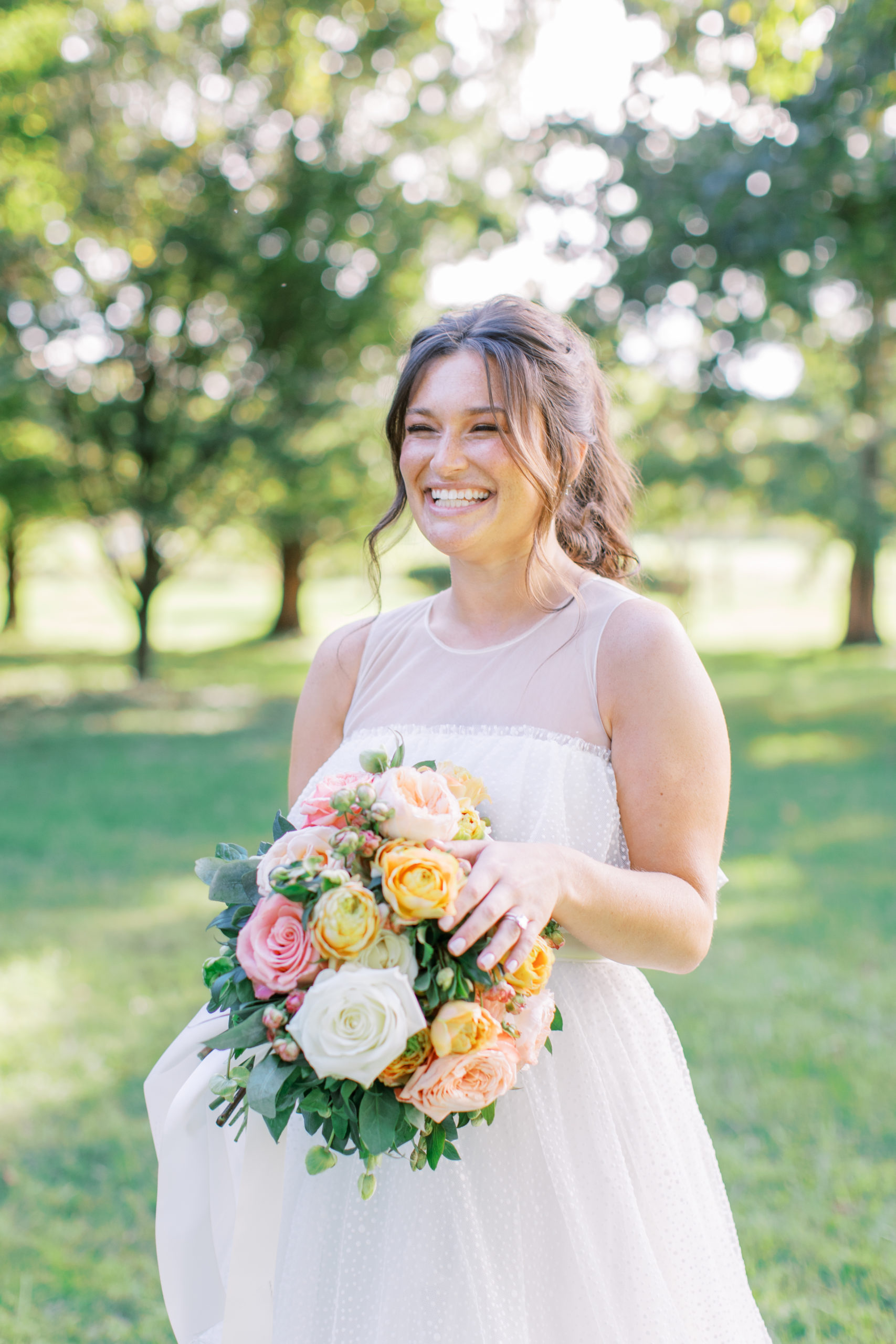 bride laughs while holding colorful bouquet amid trees NJ Private Estate Wedding Photography
