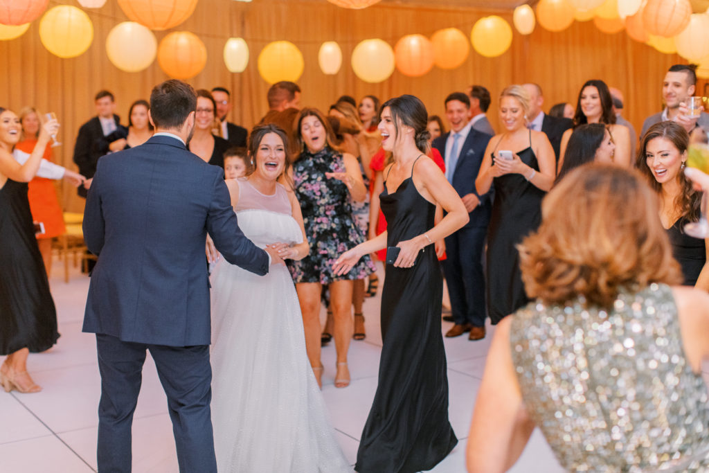 bride and groom dance with friends in gold draped tent NJ Private Estate Wedding Photography