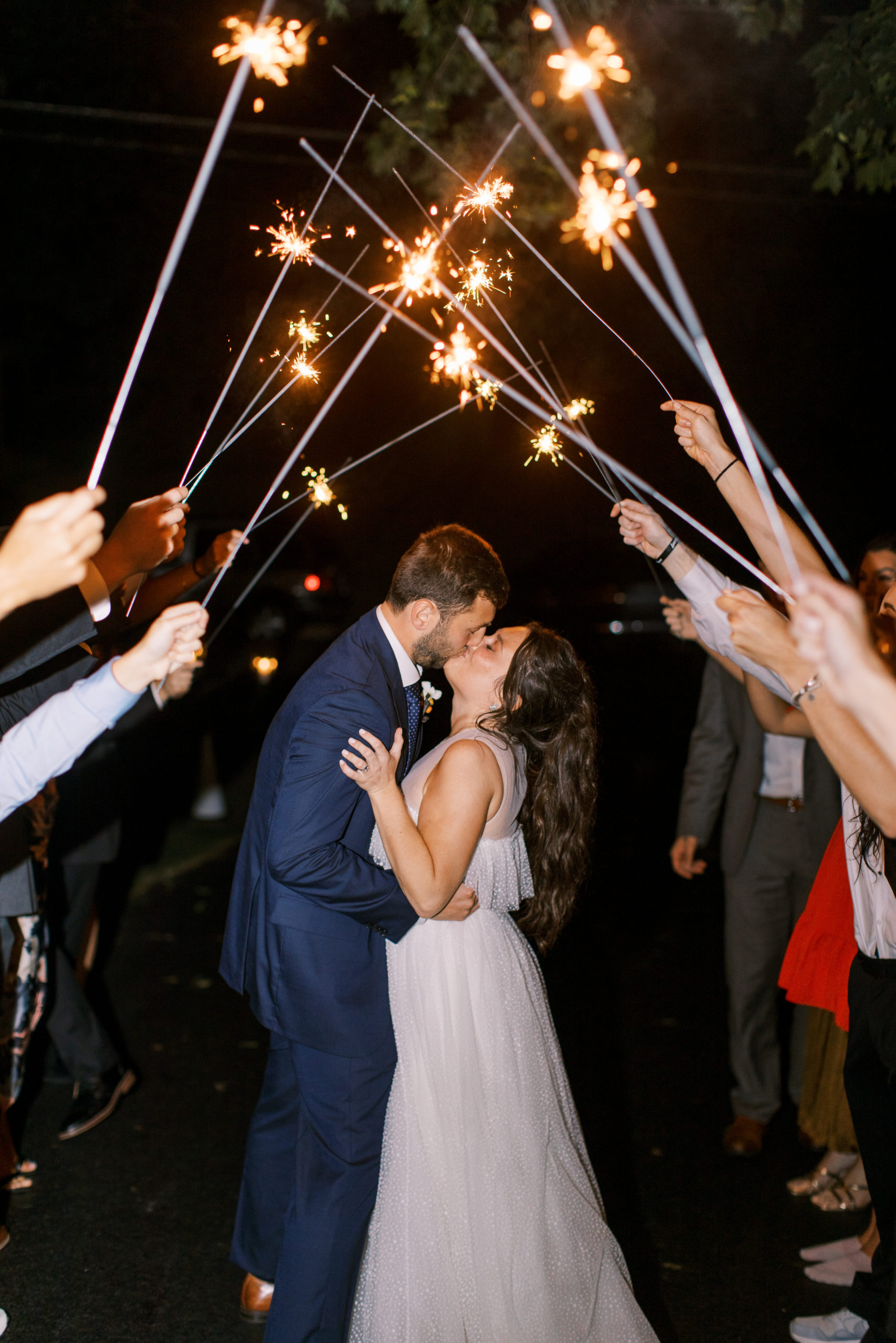 bride and groom kiss as friends hold sparkers overhead NJ Private Estate Wedding Photography