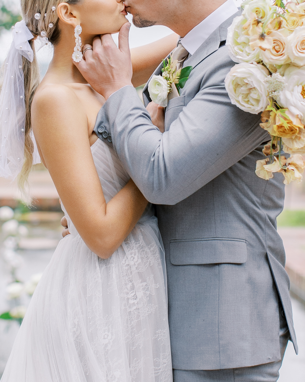 close up of bride and groom kissing in front of reflecting pool