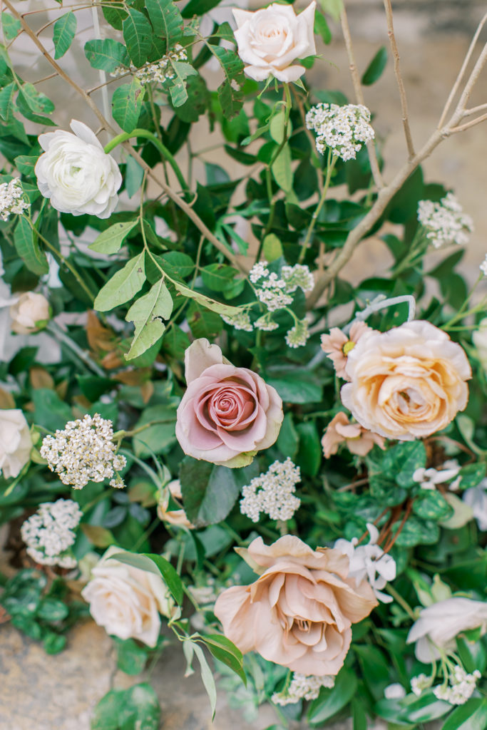 close up of blush and honey roses with greenery