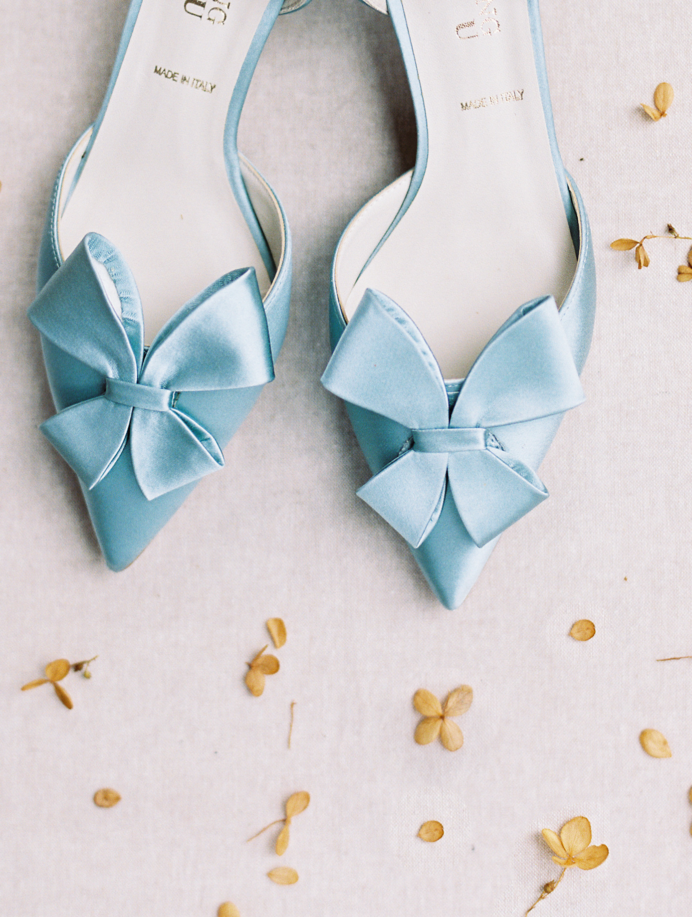 blue wedding shoes on tan mat with yellow flowers