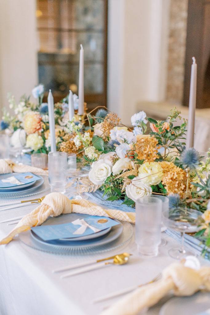 wedding reception table with blue menu cards, white roses, and gold hydrangeas Bella Collina Wedding Photography