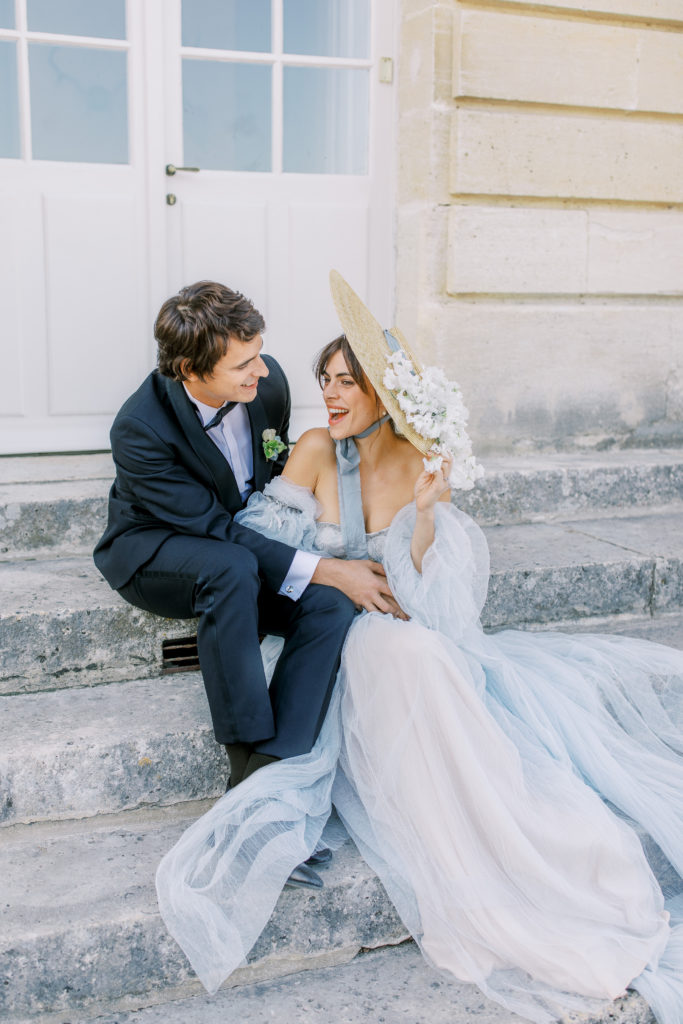 Bride and Groom laugh while seated at French chateau wedding