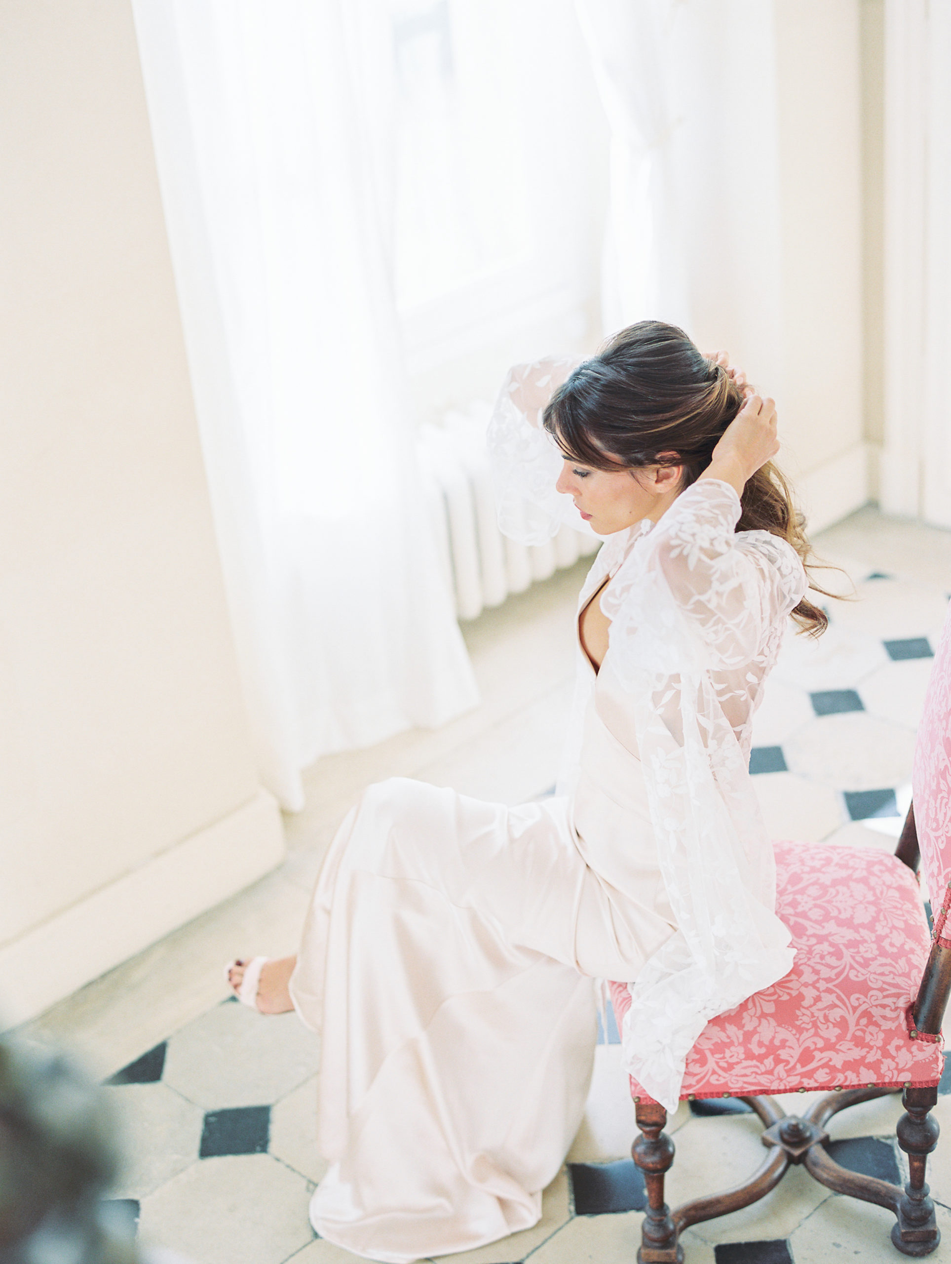 Bride gets ready in sunlit room wearing lace kimono