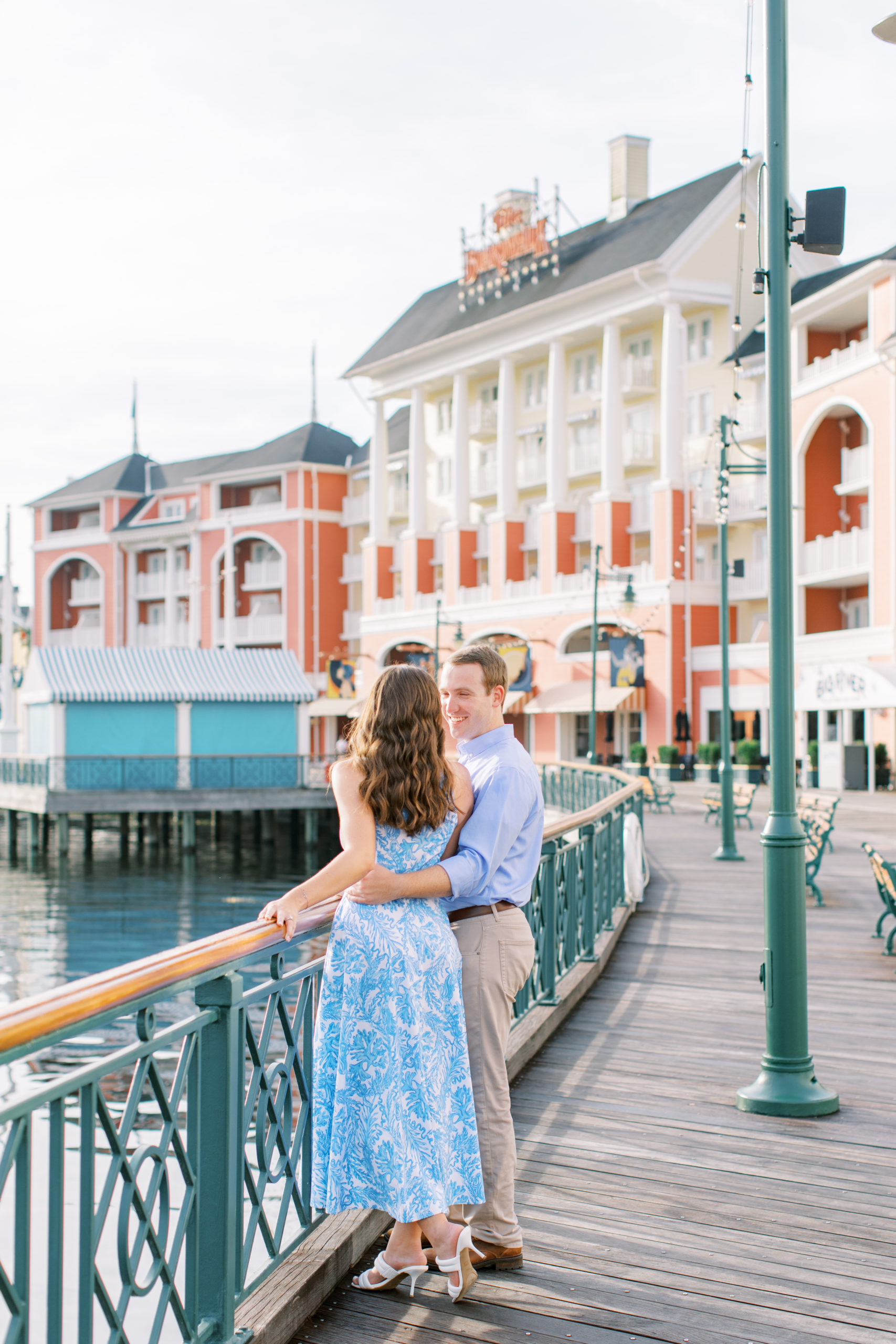 Couple stand together at railing at Disney's Boardwalk Engagement Session