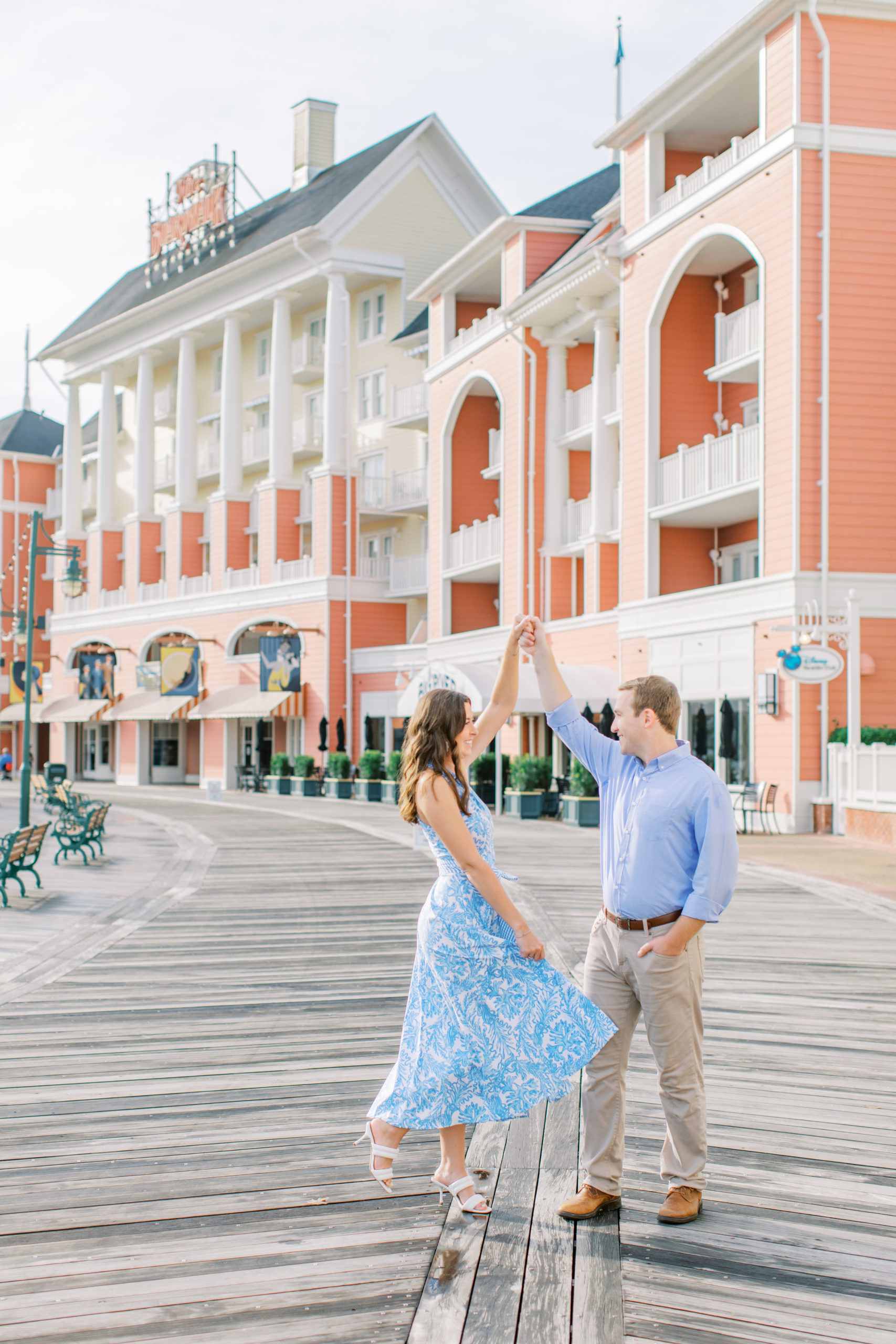 Couple dressed in blue twirl at Disney's Boardwalk Engagement Session