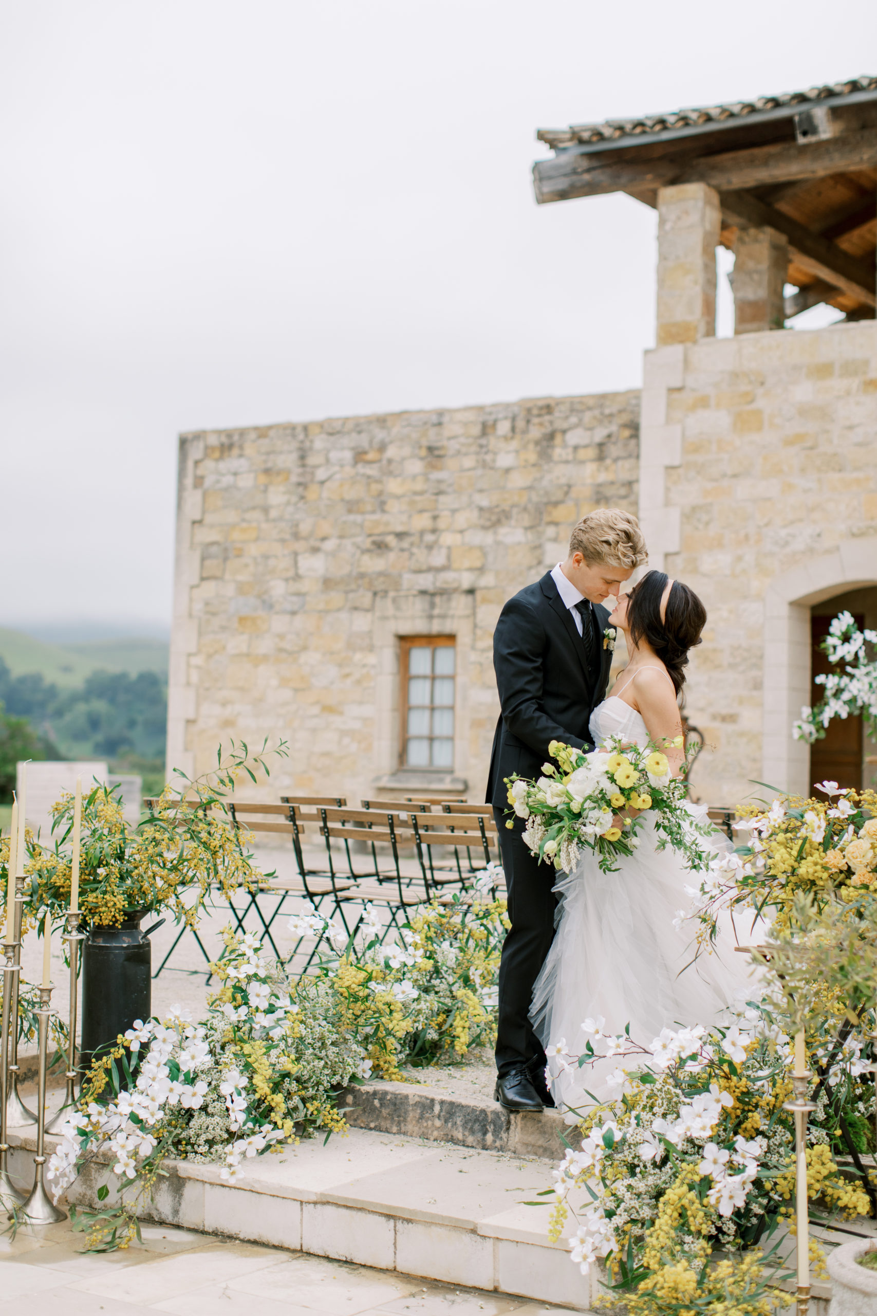 Bride and groom embrace surrounded by gold flowers at italian villa wedding Sunstone Winery Wedding Photography