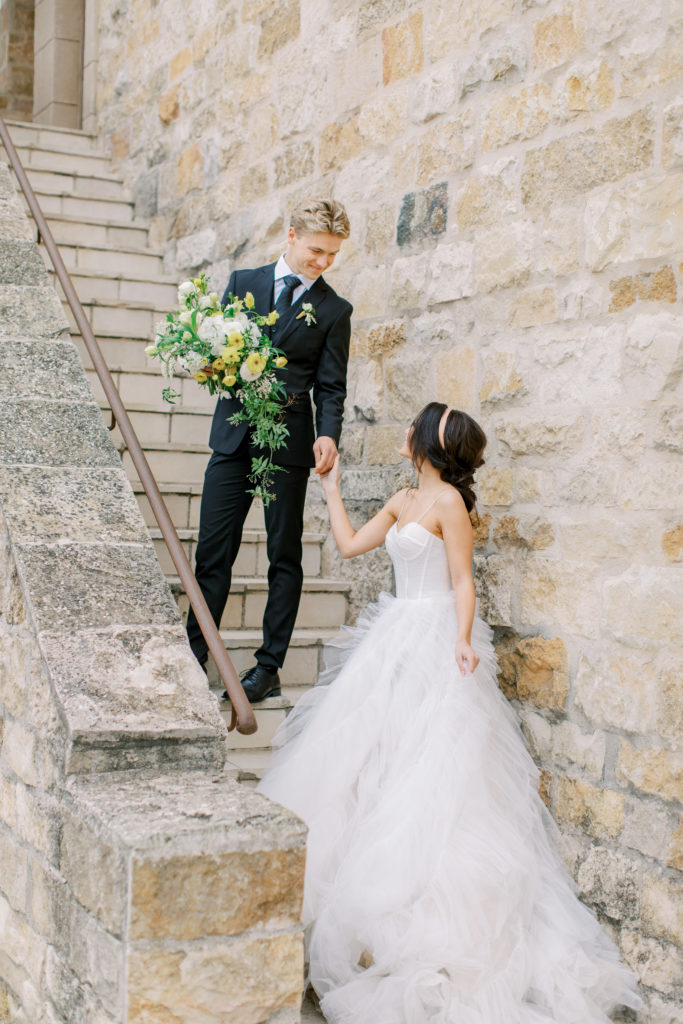 groom leads bride up stairs at italian villa wedding Sunstone Winery Wedding Photography