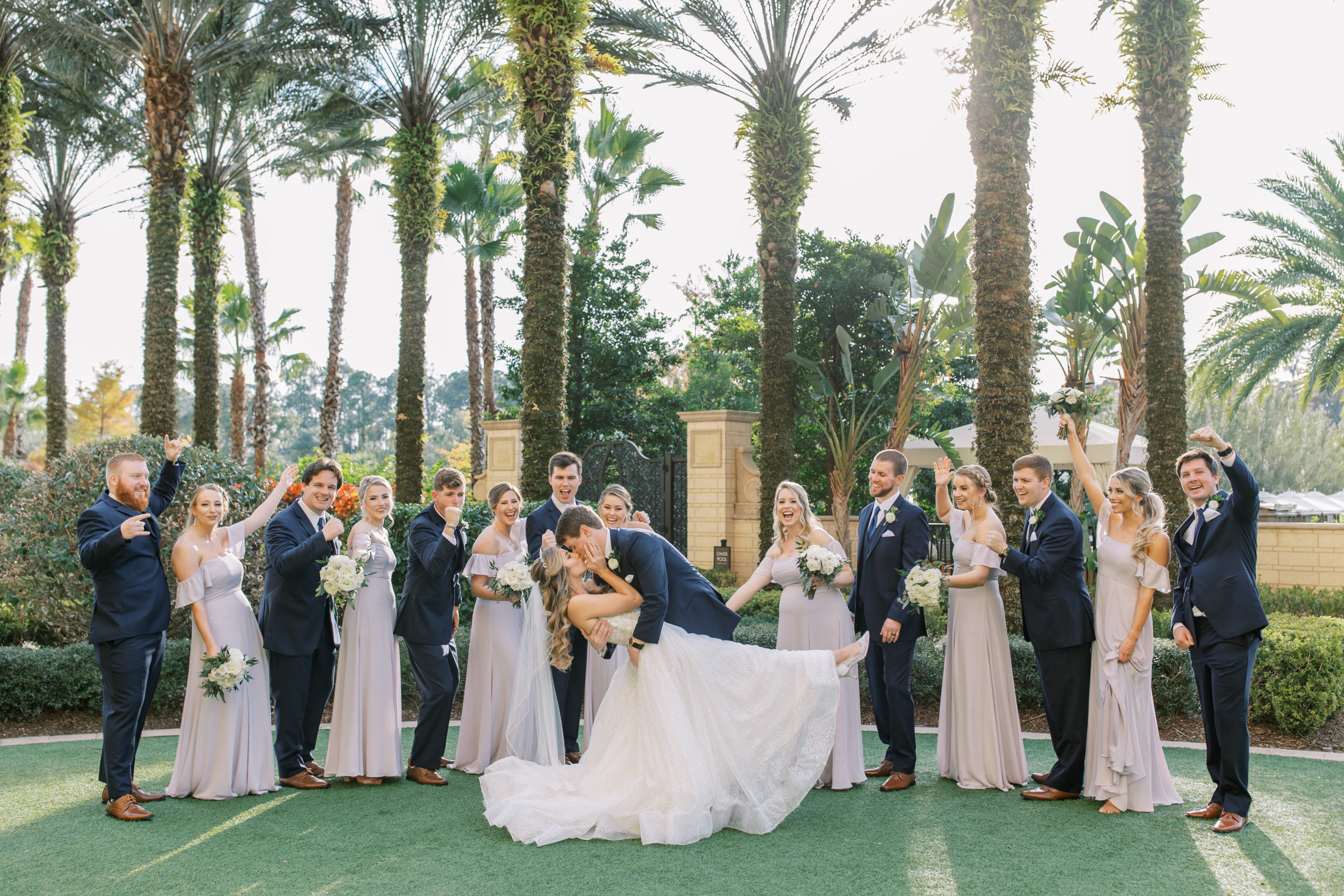 Bride and Groom kiss while wedding party cheers Four Seasons Walt Disney World Wedding Photography