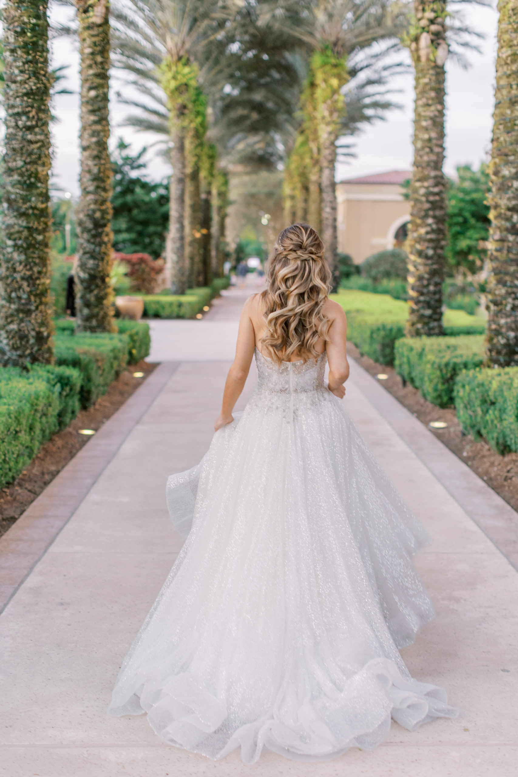 Bride walks on tree lined path at Four Seasons Walt Disney World Wedding Photography