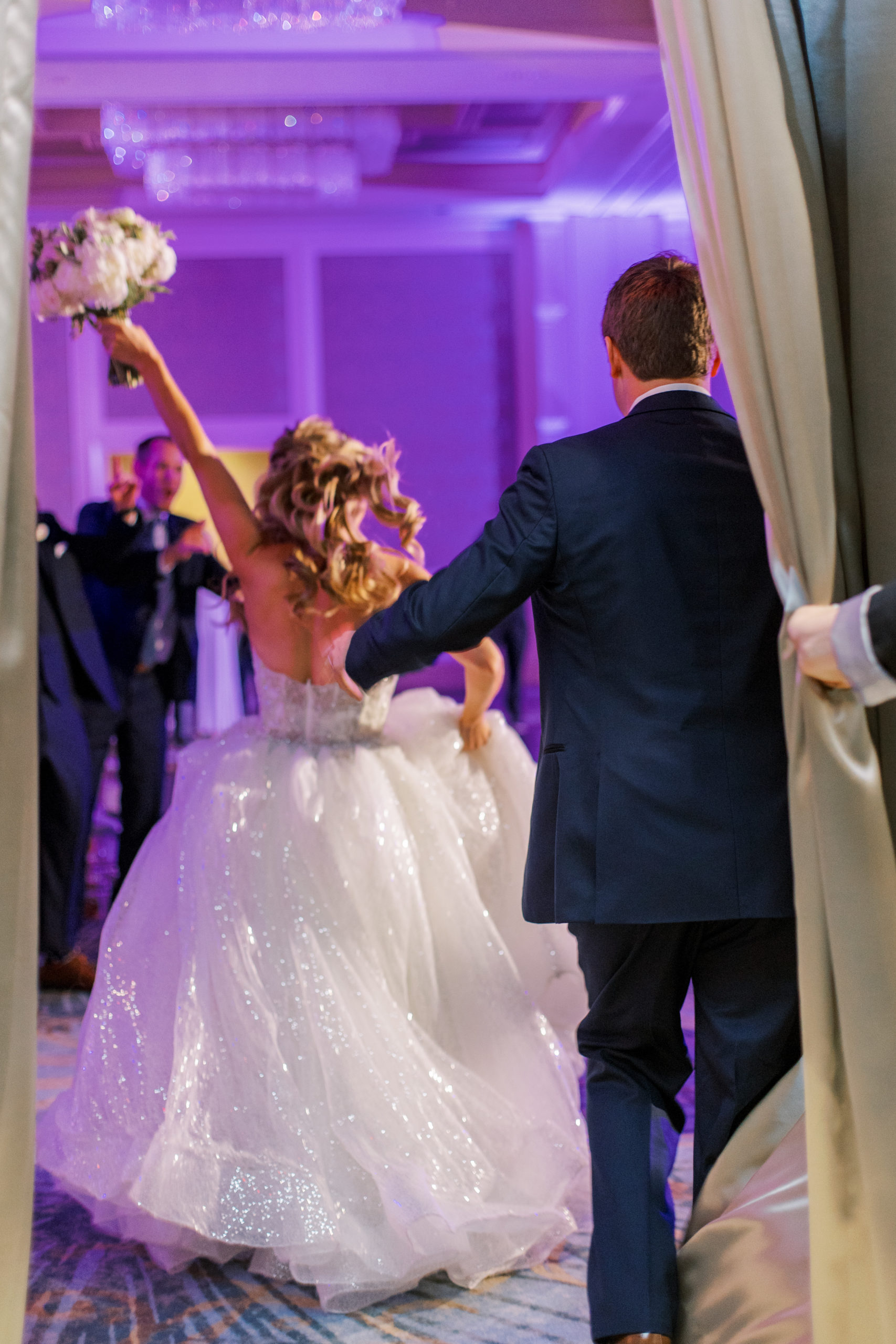 Bride and Groom celebrate as they enter reception at Four Seasons Walt Disney World Wedding Photography