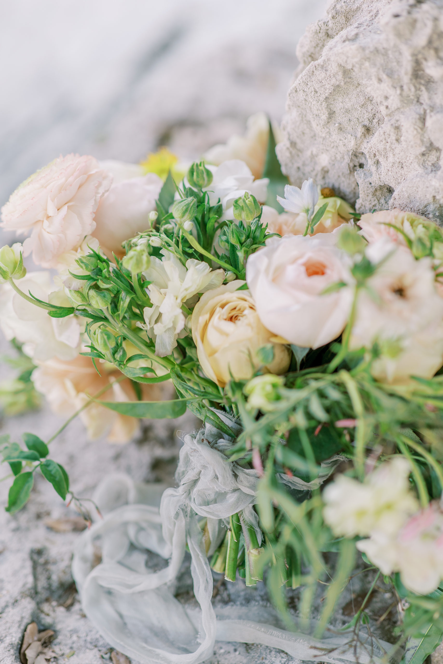 romantic wedding bouquet with roses on stone wall