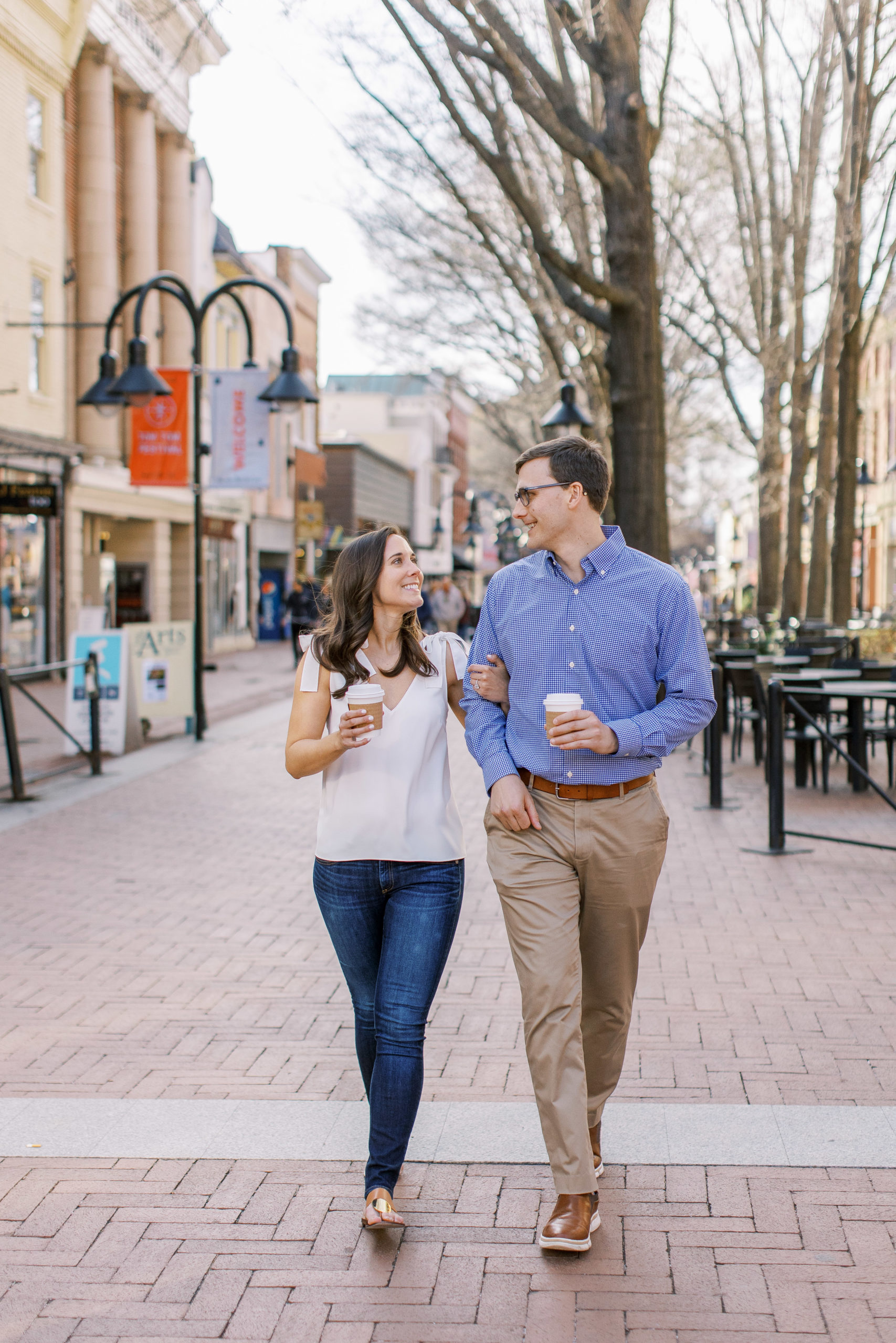 Couple walks holding coffee in downtown Charlottesville