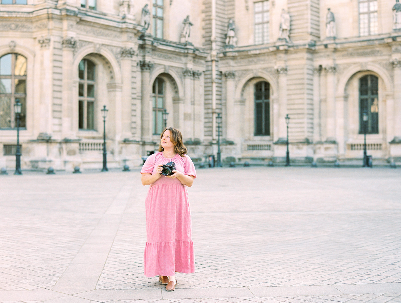 Woman in pink dress in Louvre courtyard