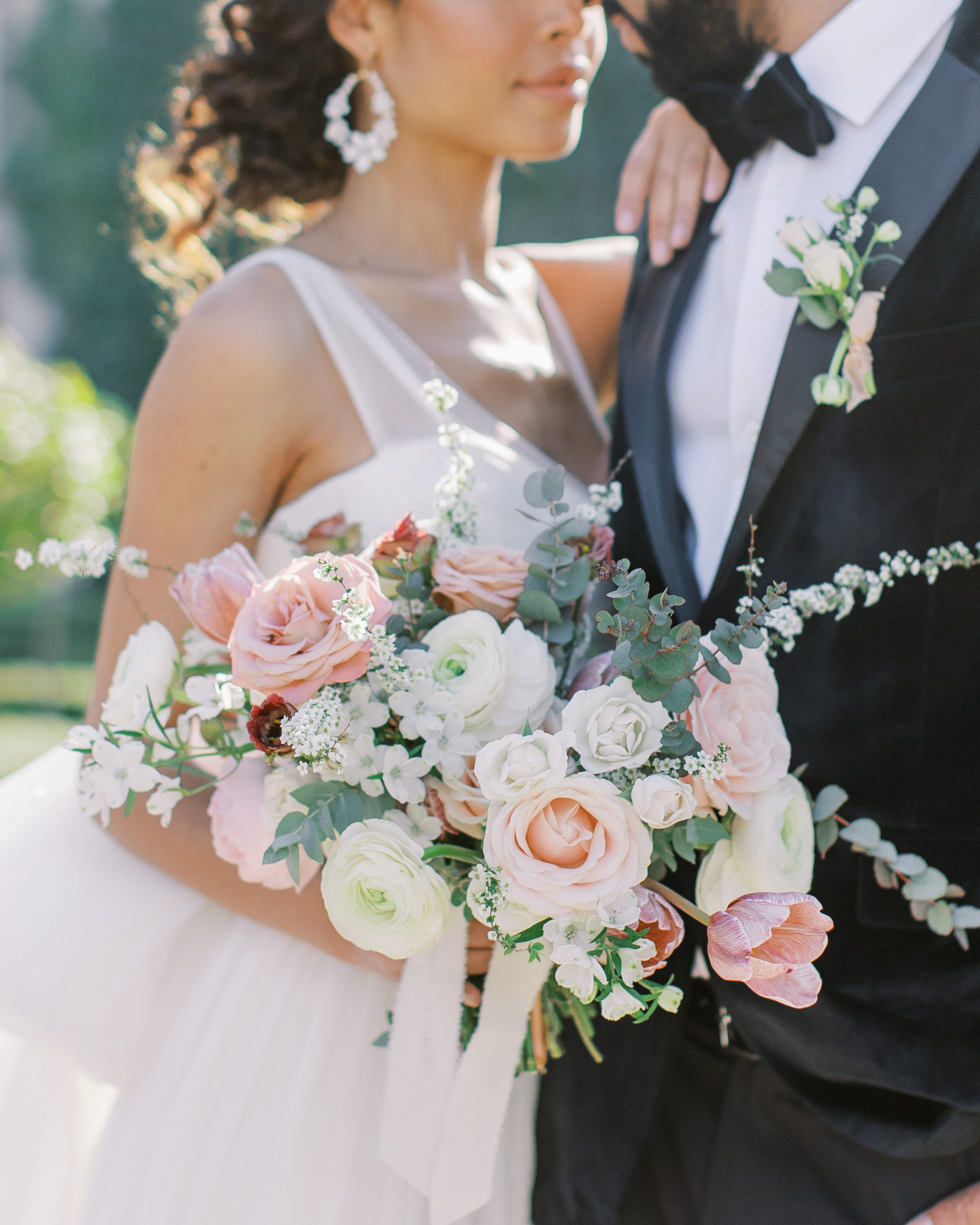 Bride and groom with beautiful cream and pink rose bouquet 