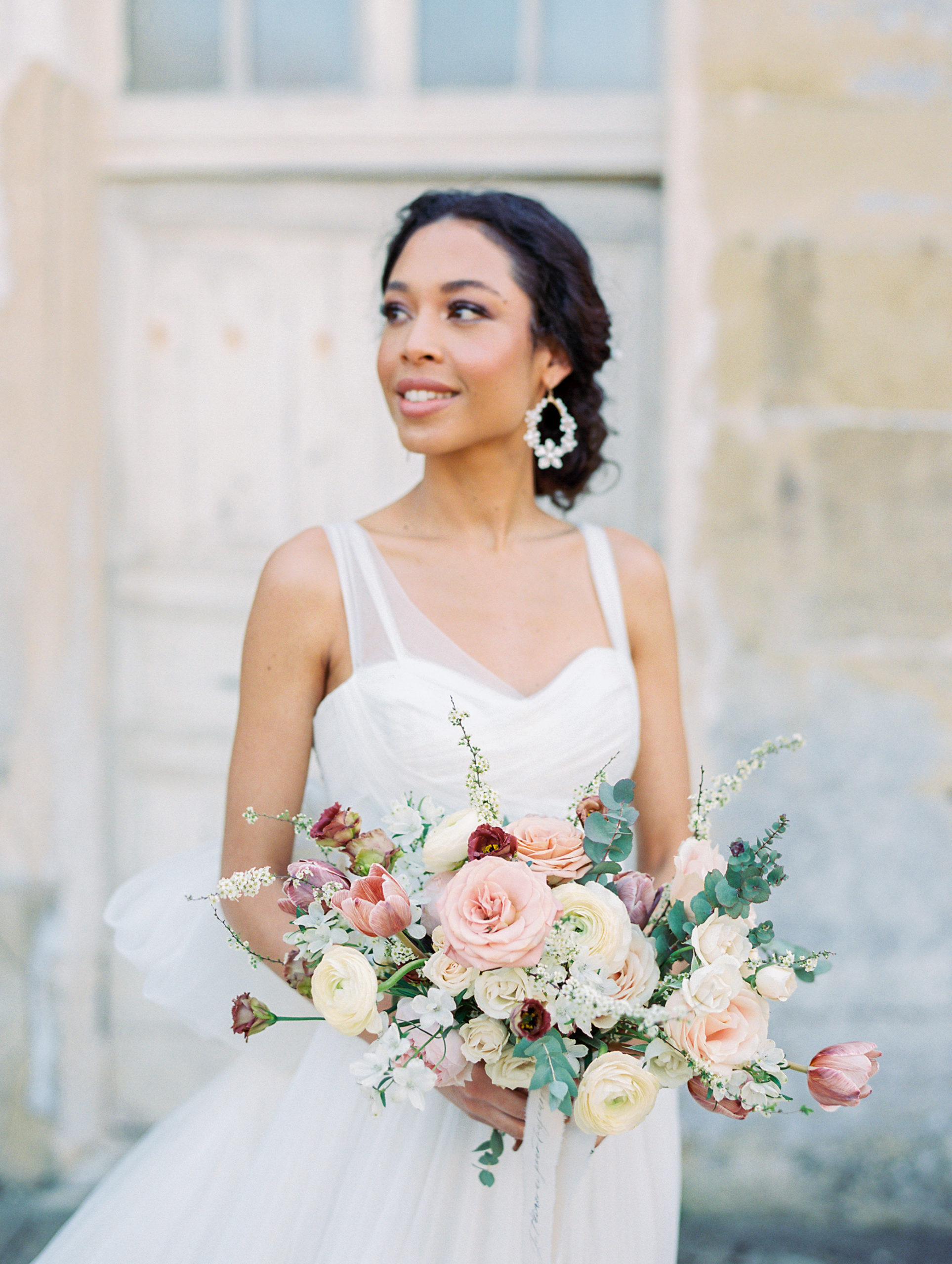 Bride holding bouquet of pink and cream flowers 