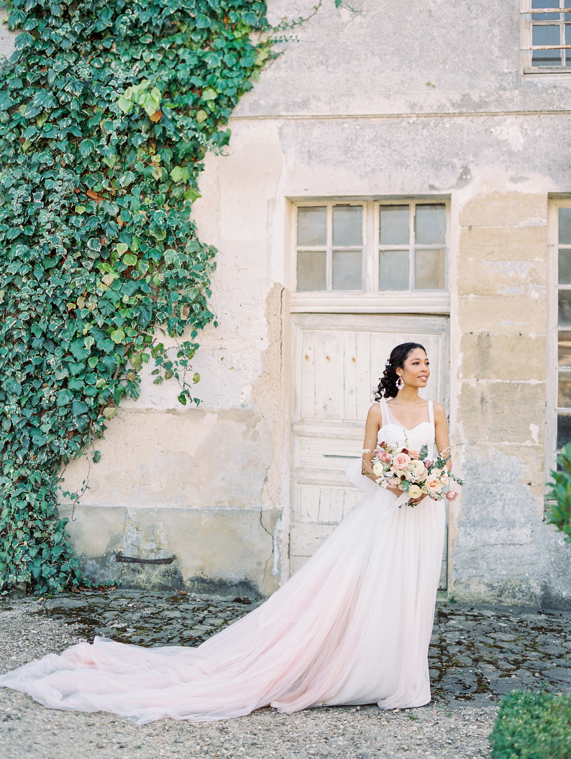 Bride and rose bouquet with a vine wall behind at Chateau de Villette Wedding Photography