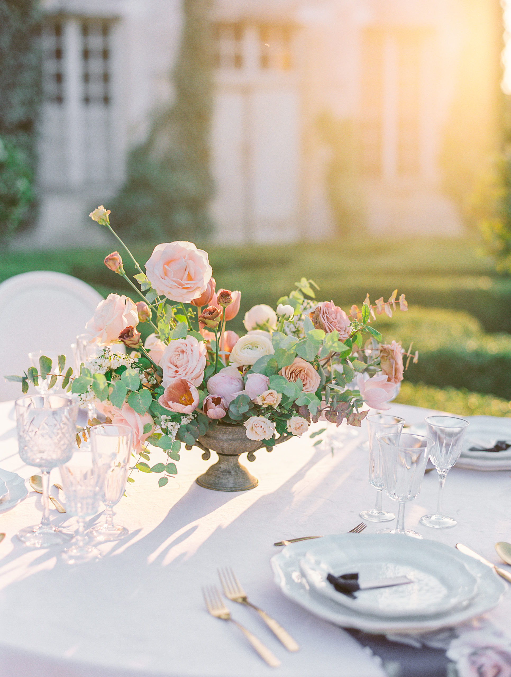Flower arrangement of pink, cream, and orange roses on wedding reception table at Chateau de Villette Wedding Photography