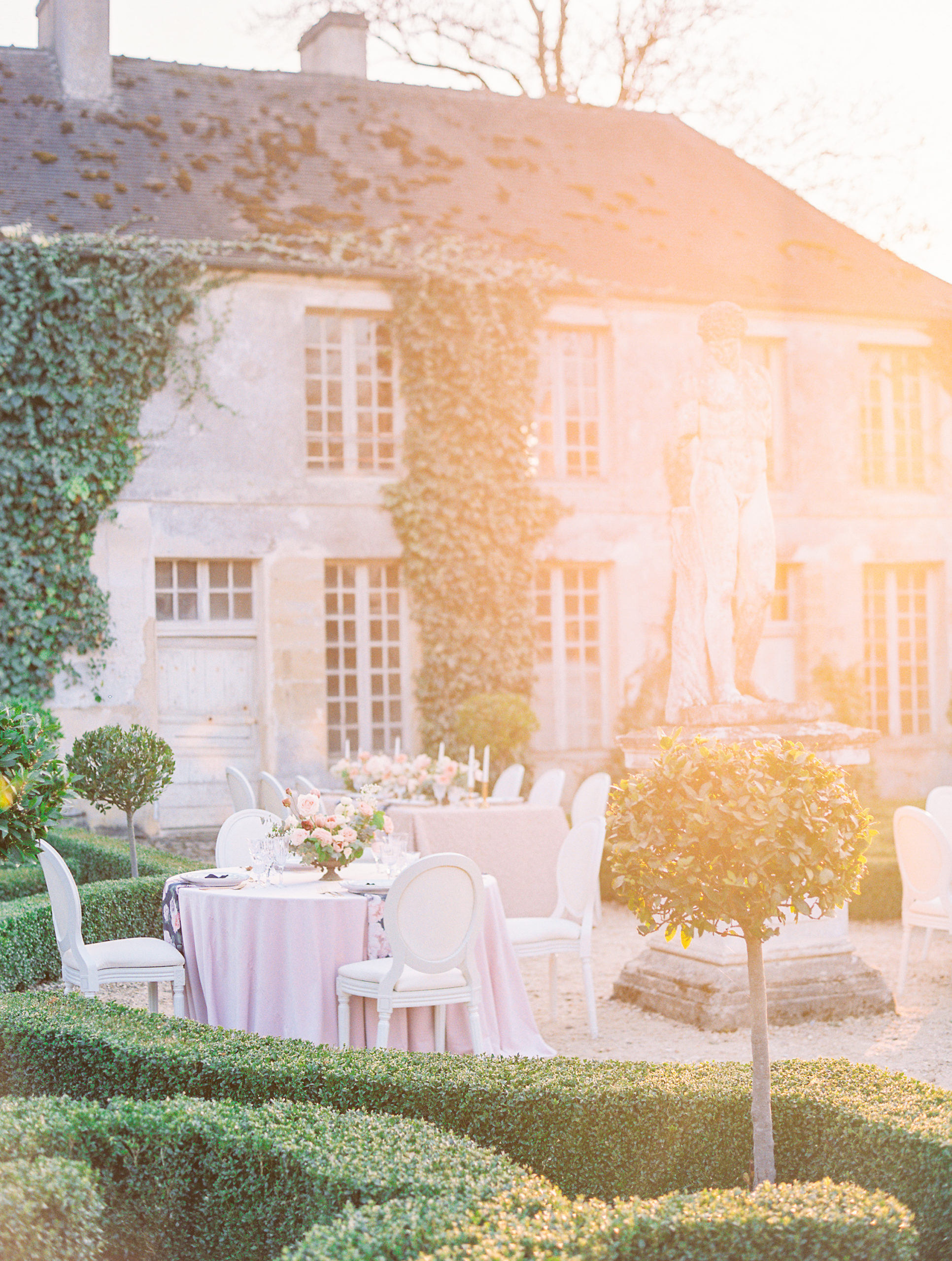 Wedding reception golden hour in garden with statue and table settings at Chateau de Villette Wedding Photography