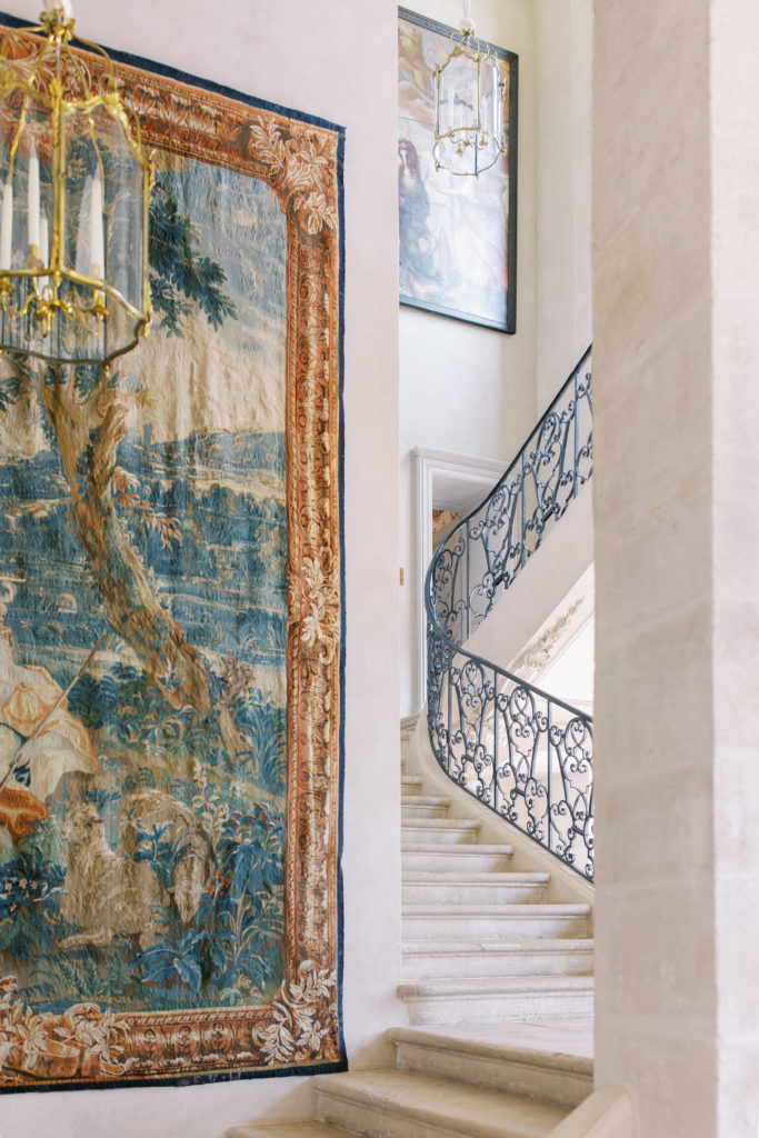 Large tapestry and gold fixtures with grand staircase 