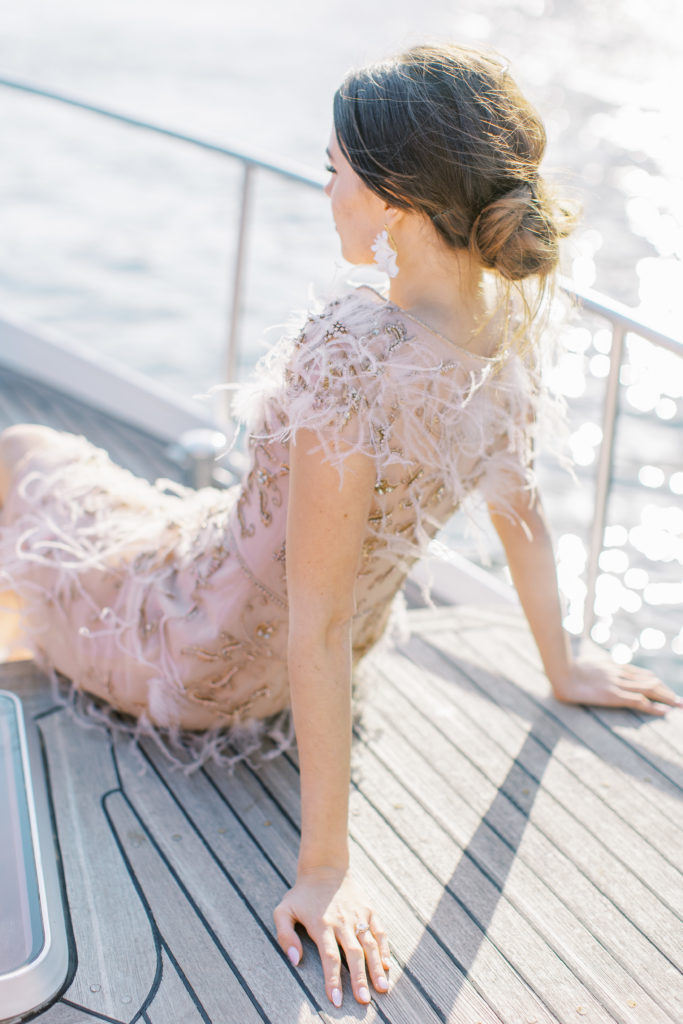 Bride laying on boat in pink dress for Sunset Paris Engagement 