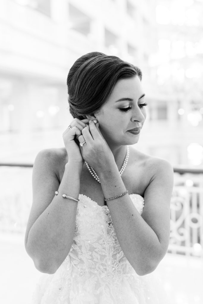 Bride smiles and puts on earrings for a Romantic and Timeless Grand Floridian Wedding 