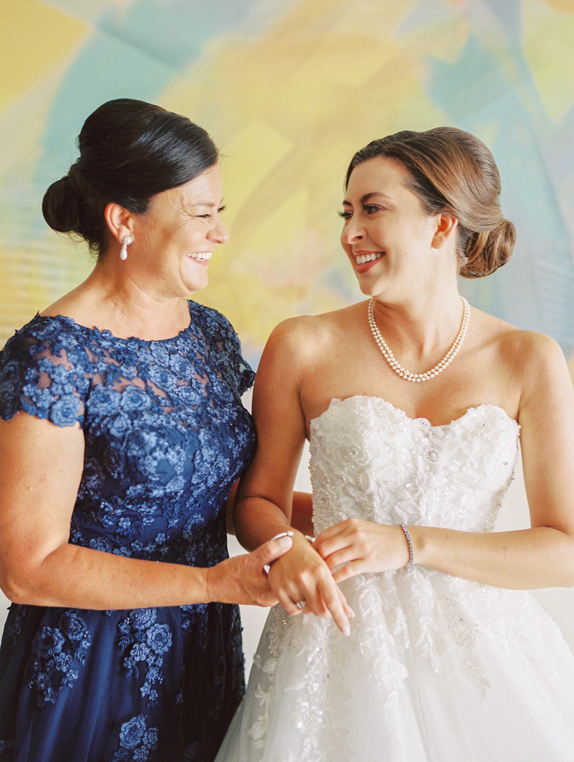 Mother of the bride and daughter smile and laugh before wedding at a Romantic and Timeless Grand Floridian Wedding 