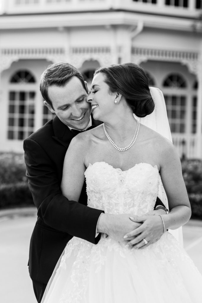 Black and white portrait of groom holding bride and smiling at a Romantic and Timeless Grand Floridian Wedding 