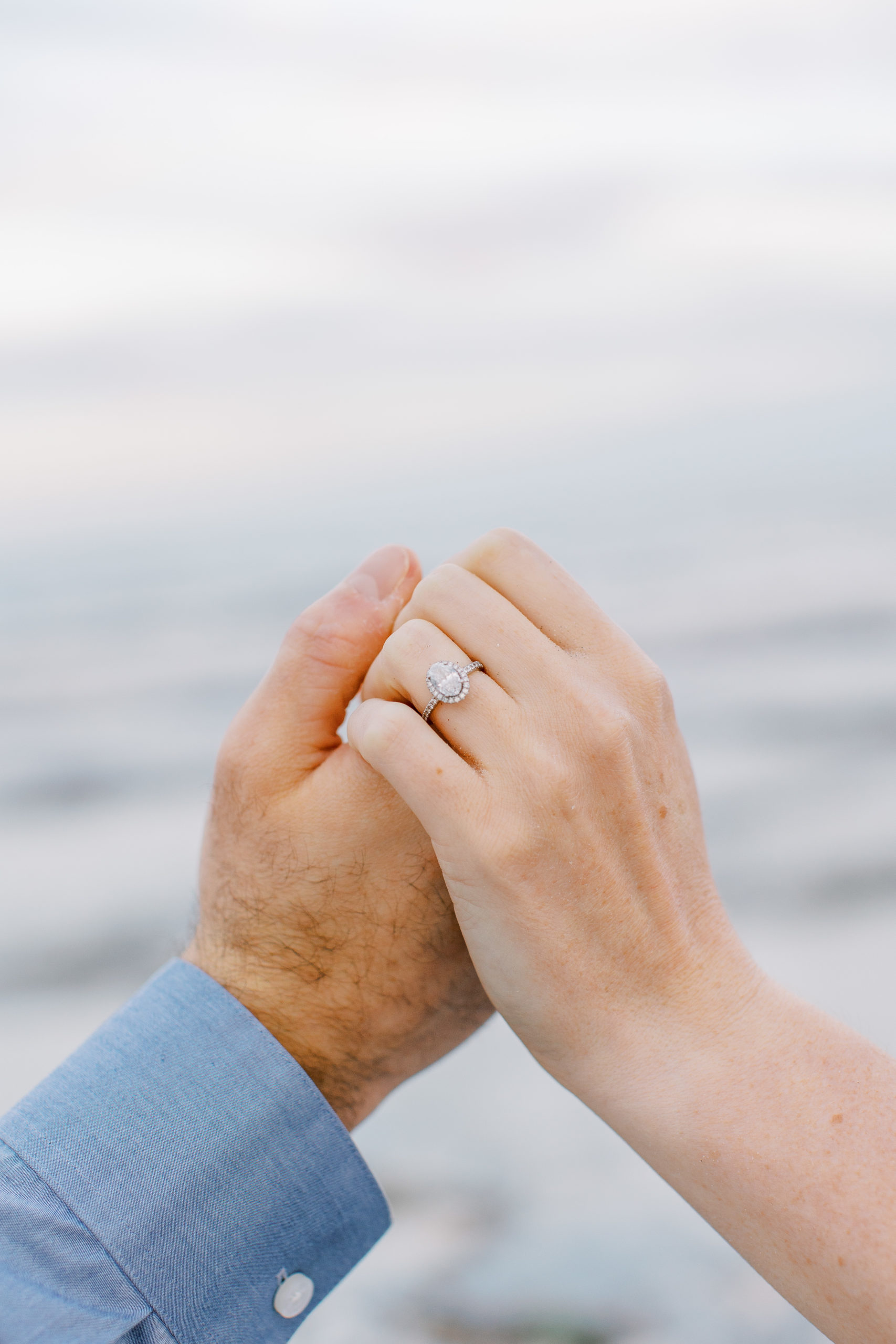 Up close of couples hands with engagement ring at the beach for Coastal Maine Engagement Session 