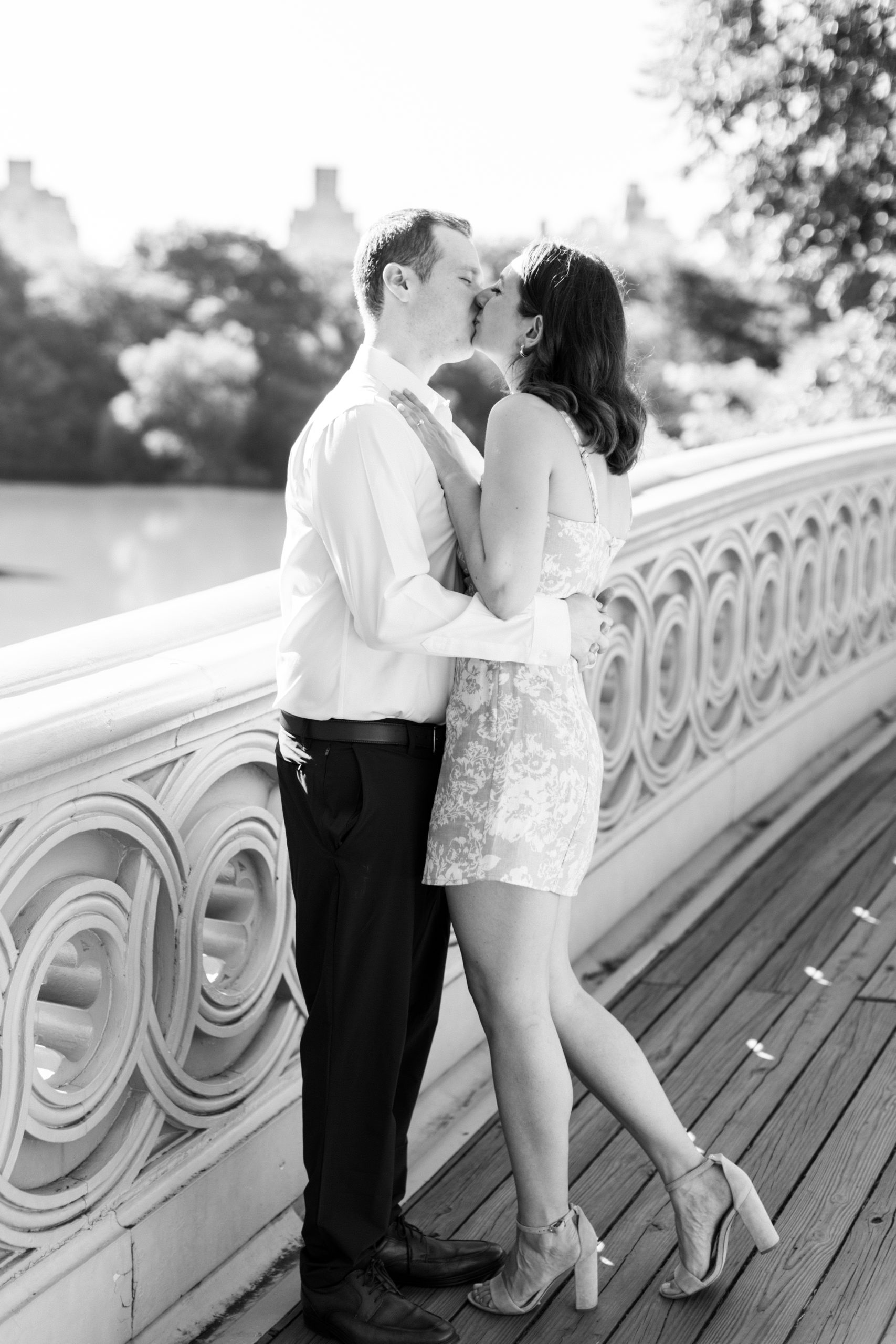 Couple embrace and kiss on wooden bridge in the park for Central Park Engagement Photos