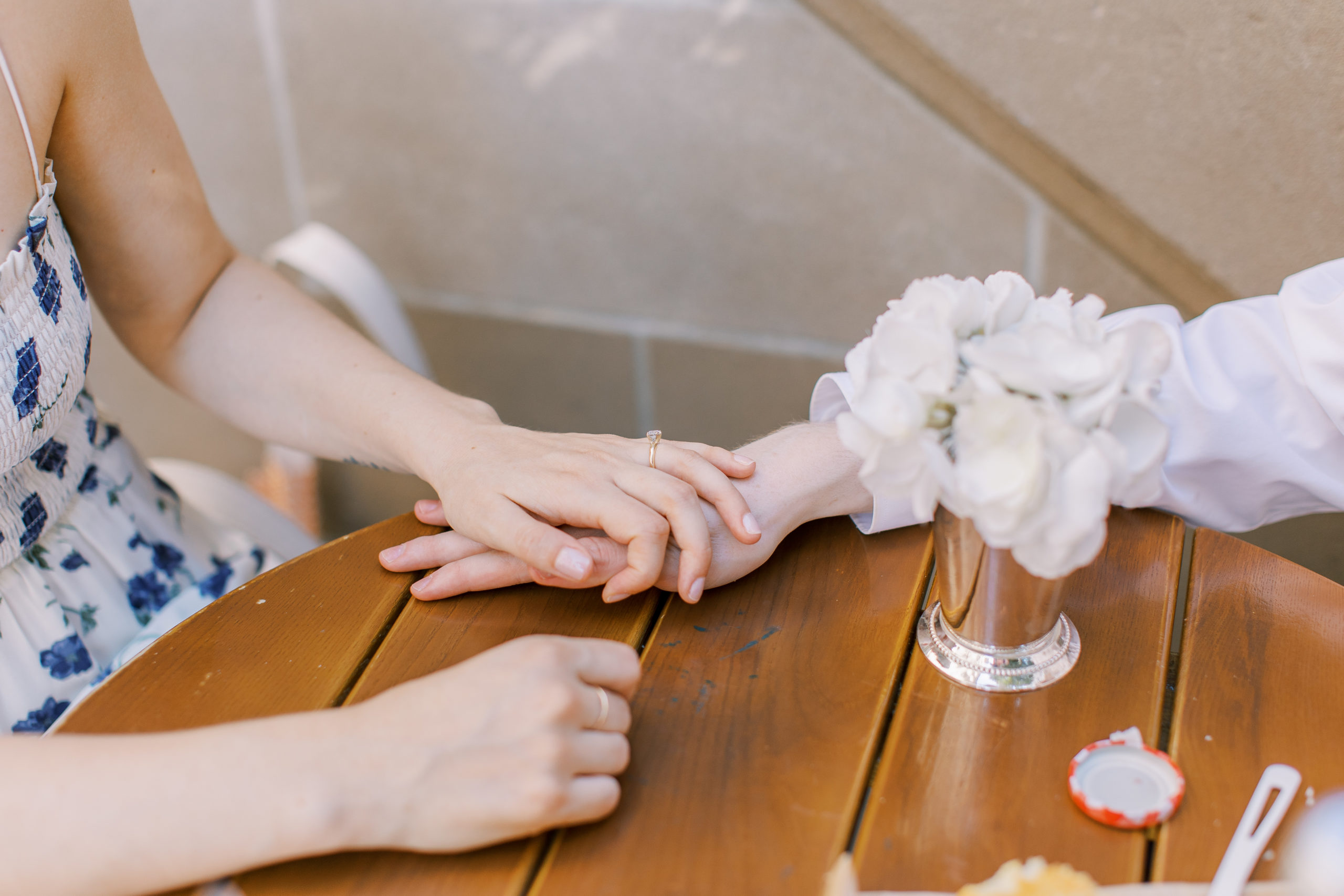 Couple holds hands ont op of table with engagement ring for Central Park Engagement Photos