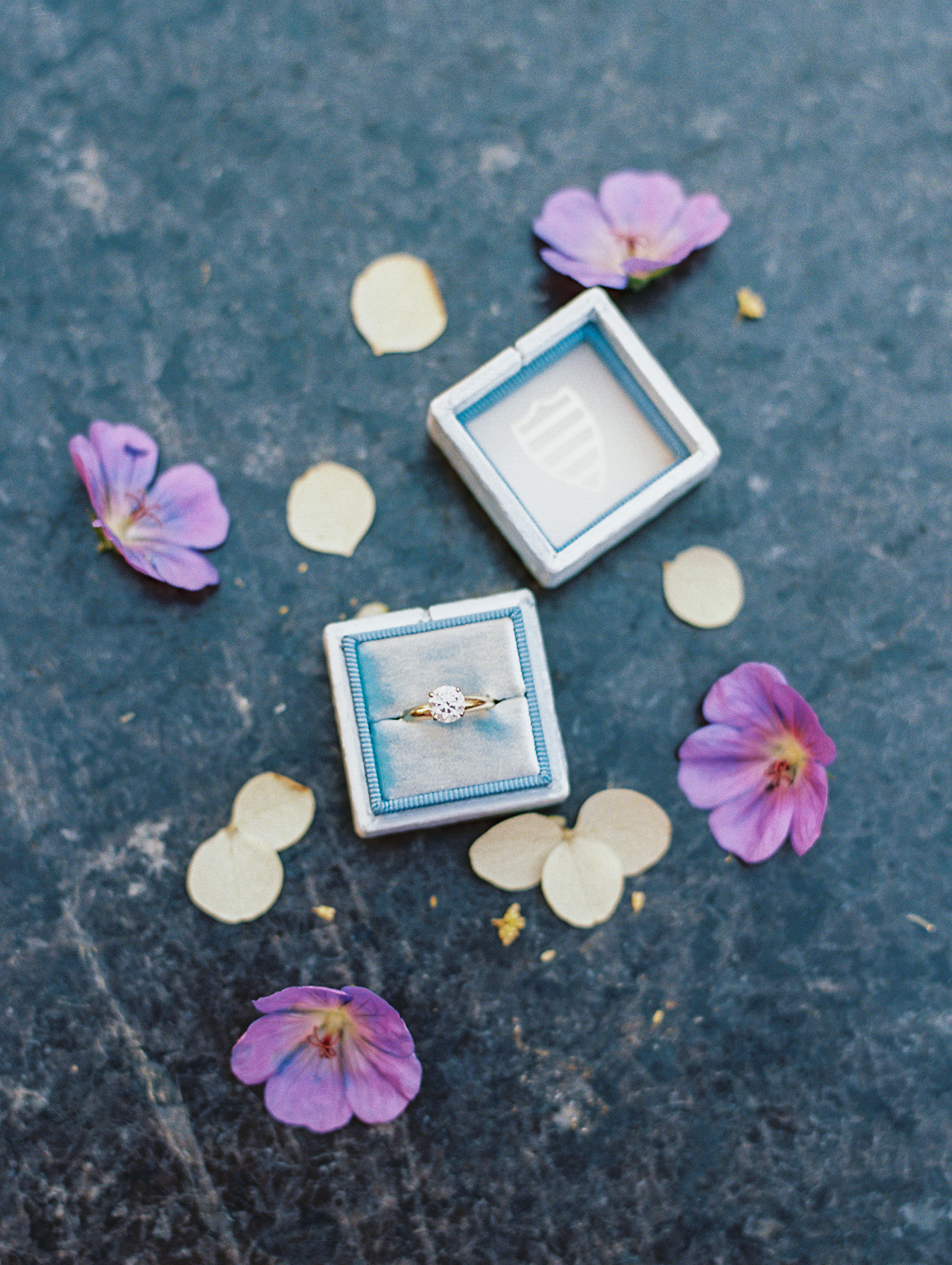 Engagement ring in blue box with purple and ivory flowers for Central Park Engagement Photos