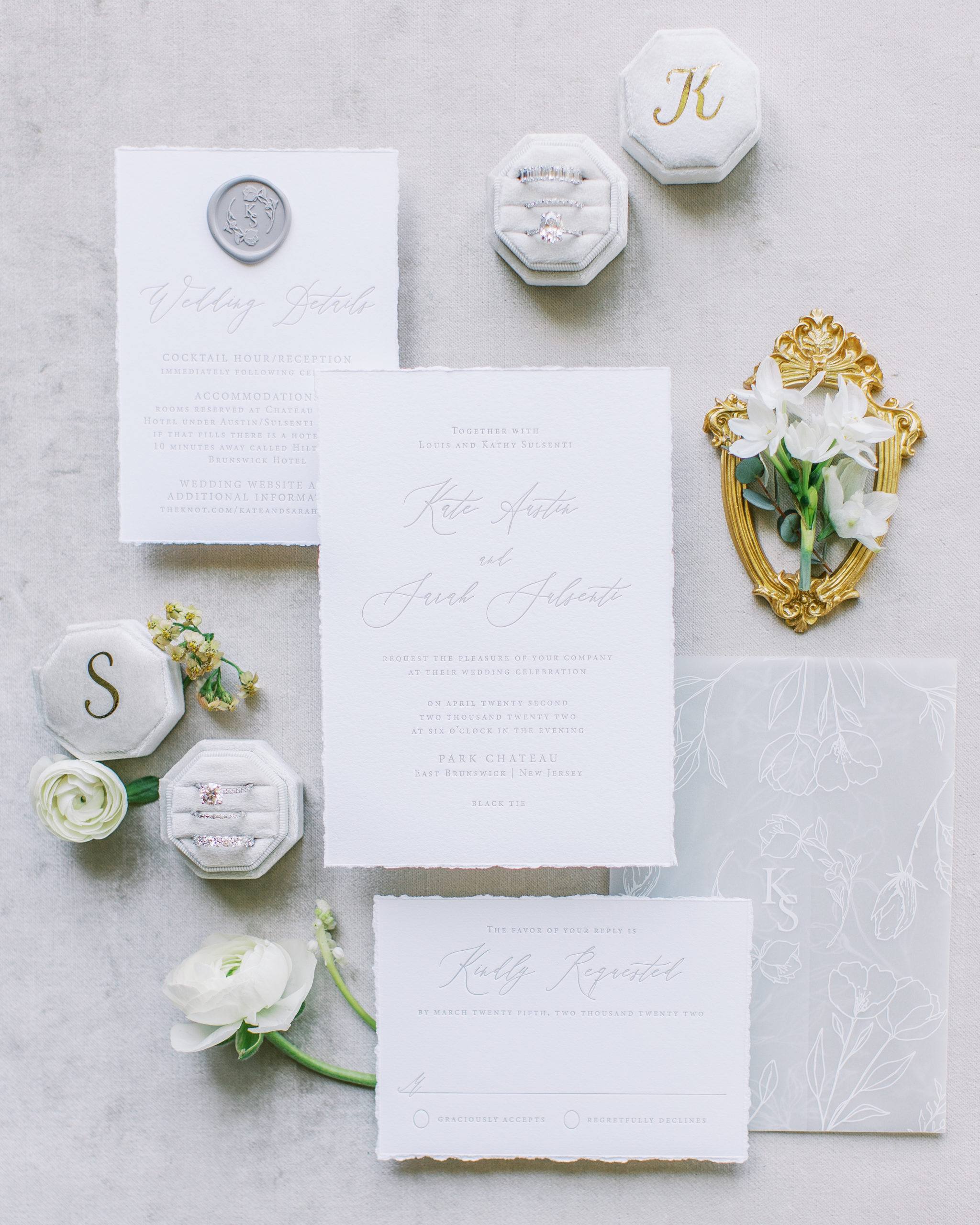 Ivory wedding invitations with ring boxes and white flowers and small gold frame