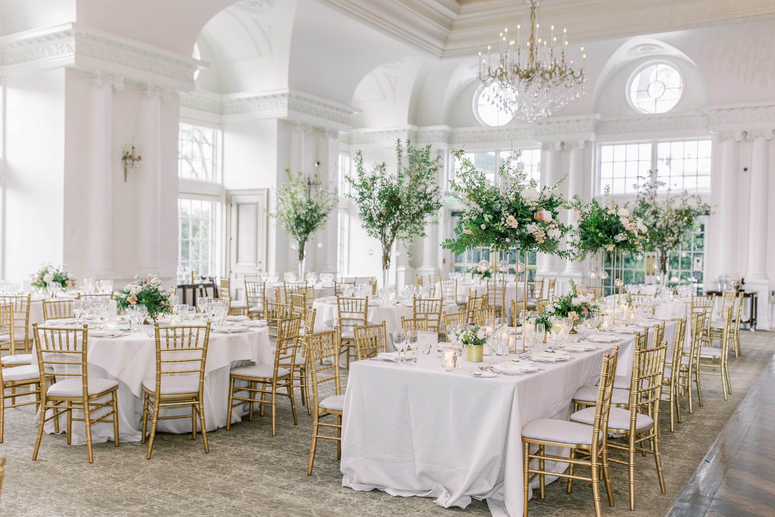 Wedding reception with large rose centerpieces and crystal chandelier 