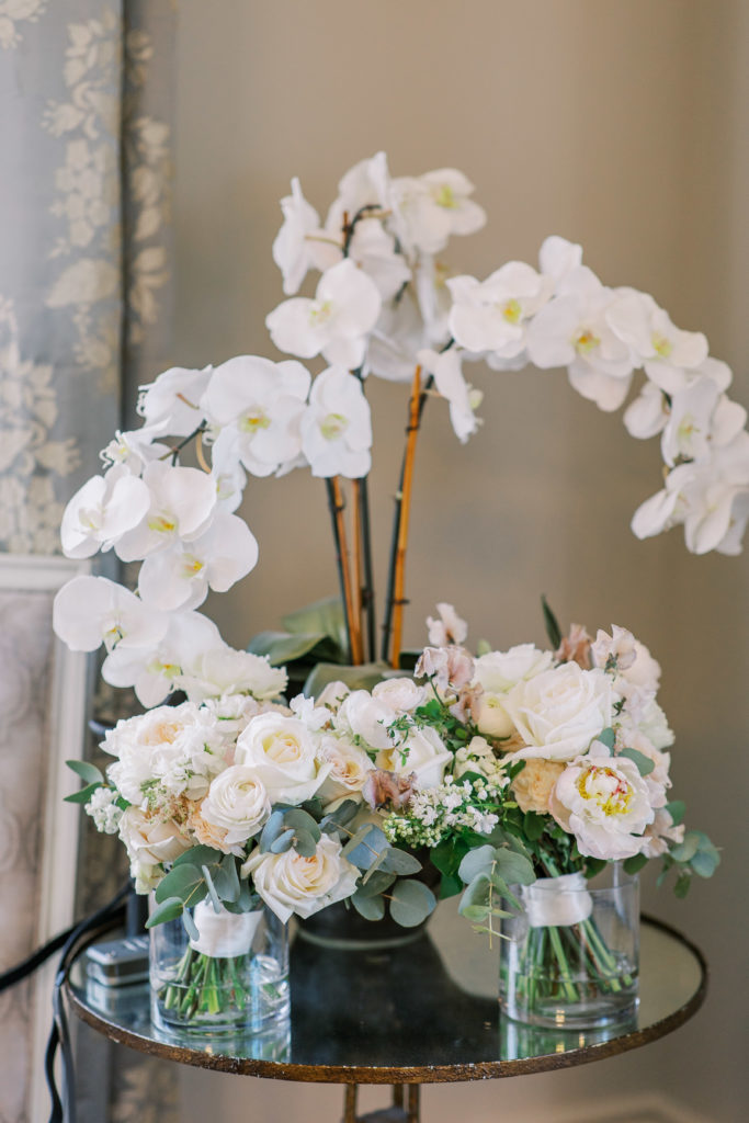 Peach and white rose bouquets resting on table with white orchid 