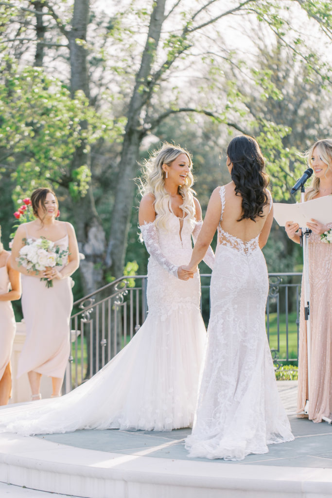 Brides hold hands at chateau wedding venue