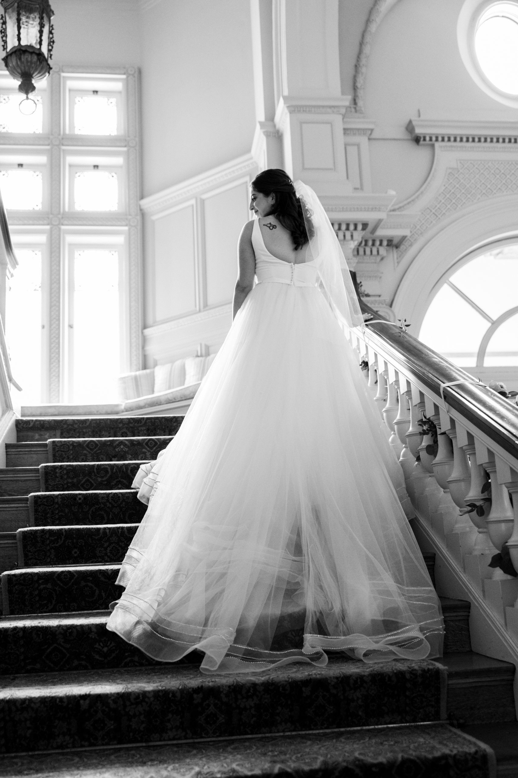 Bride walks away up staircase 