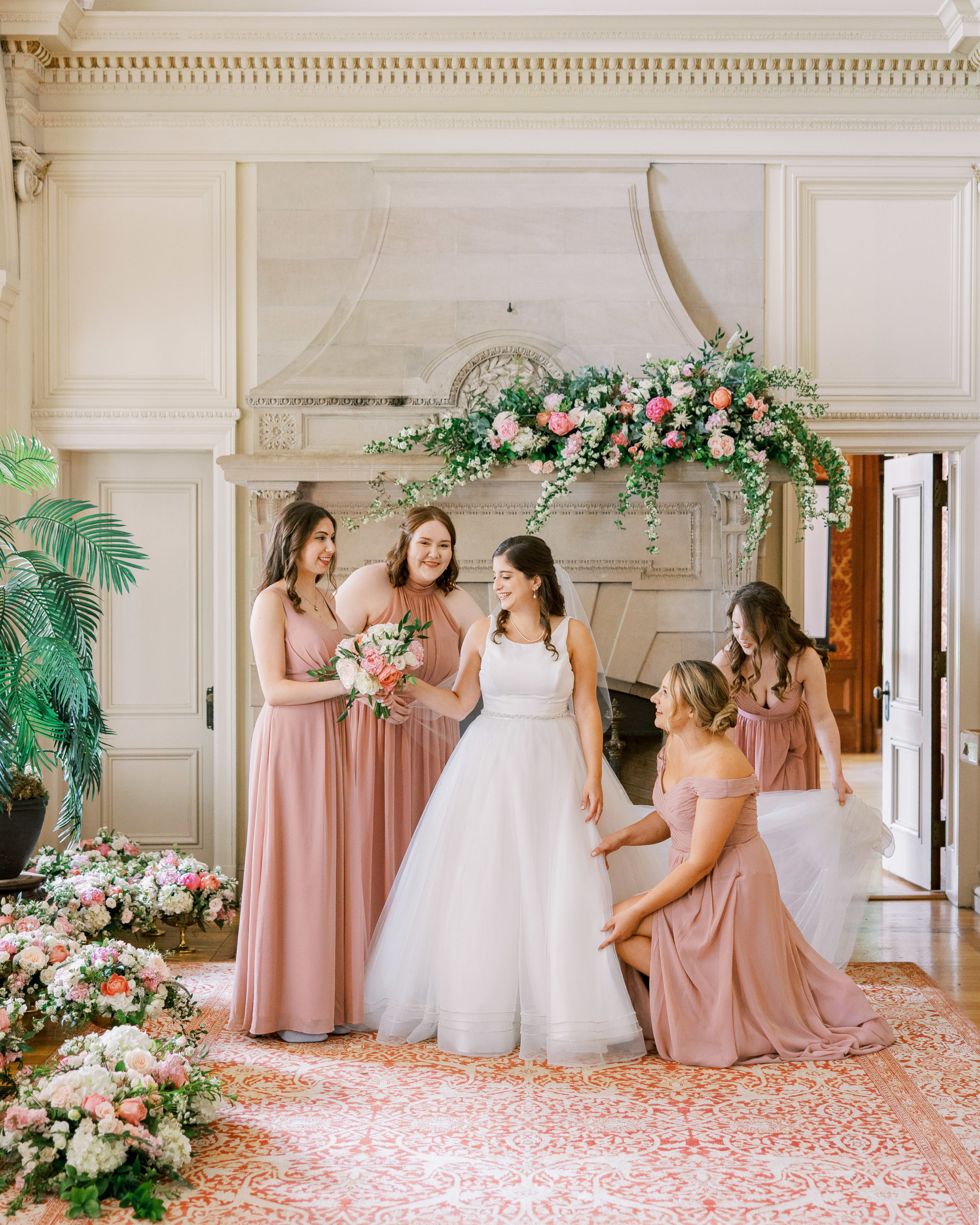 Bridesmaid surround bride and help with dress and flowers at Cairnwood Estate Wedding Photography