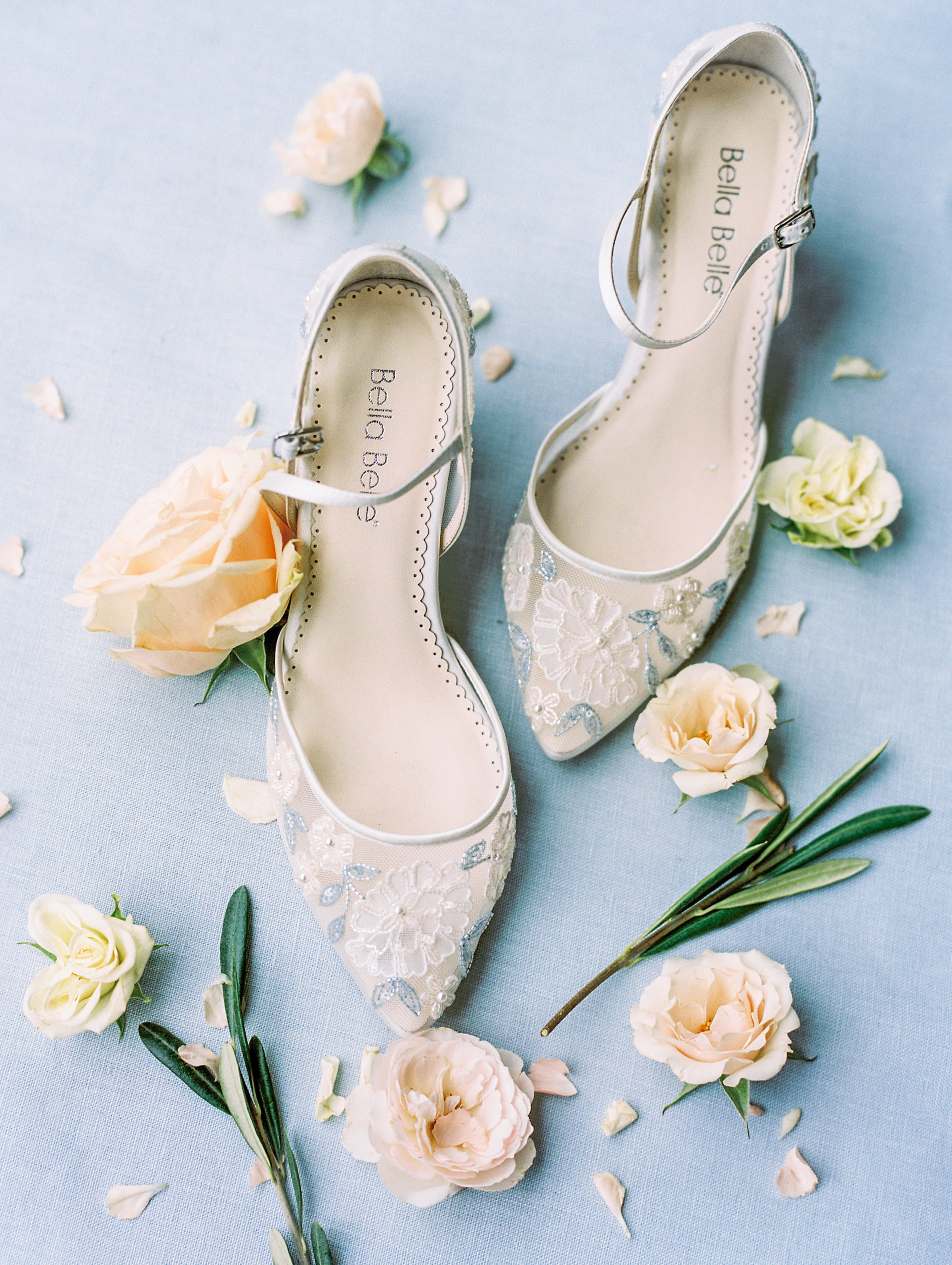 Light blue and ivory embellished wedding heels with rose petals and olive leaves at Cairnwood Estate Wedding Photography