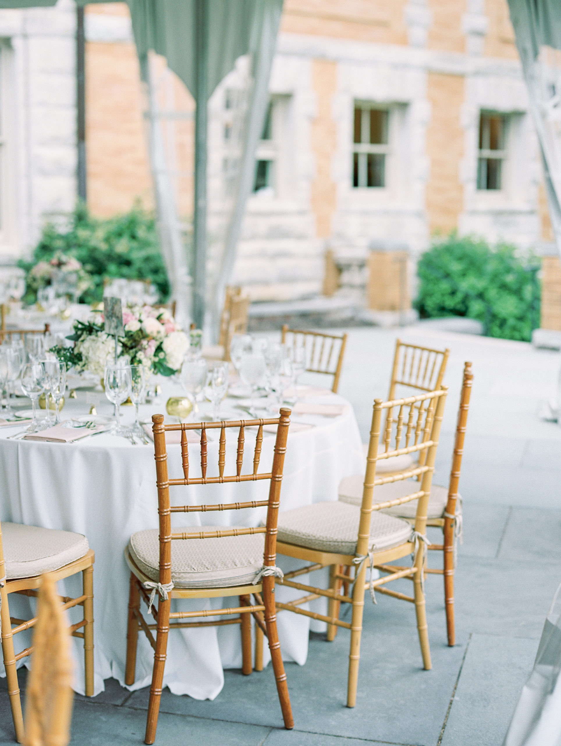 Wedding reception table with gold chairs and rose center pieces 