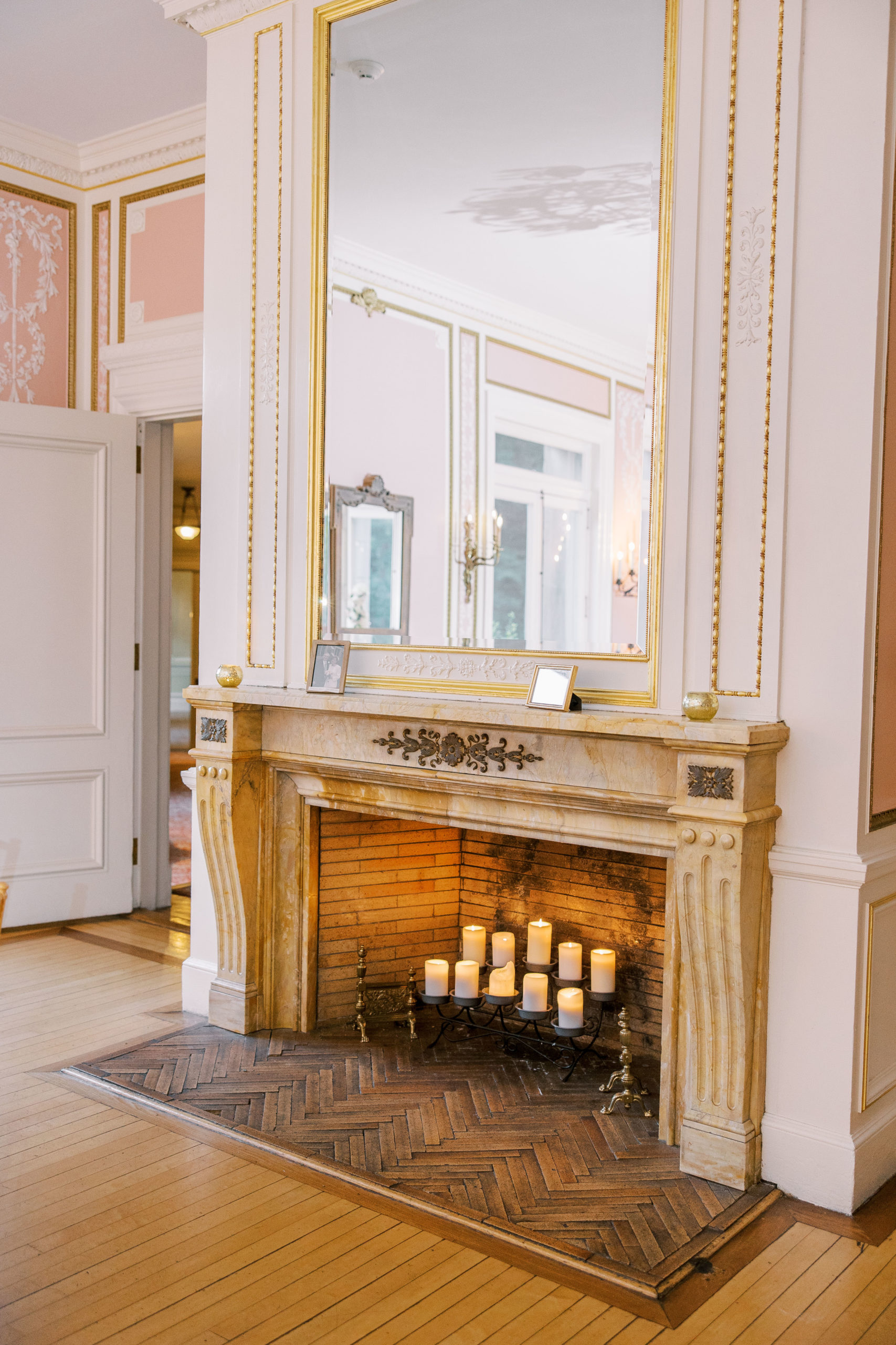 Stone fireplace with gold framed mirror and candles 