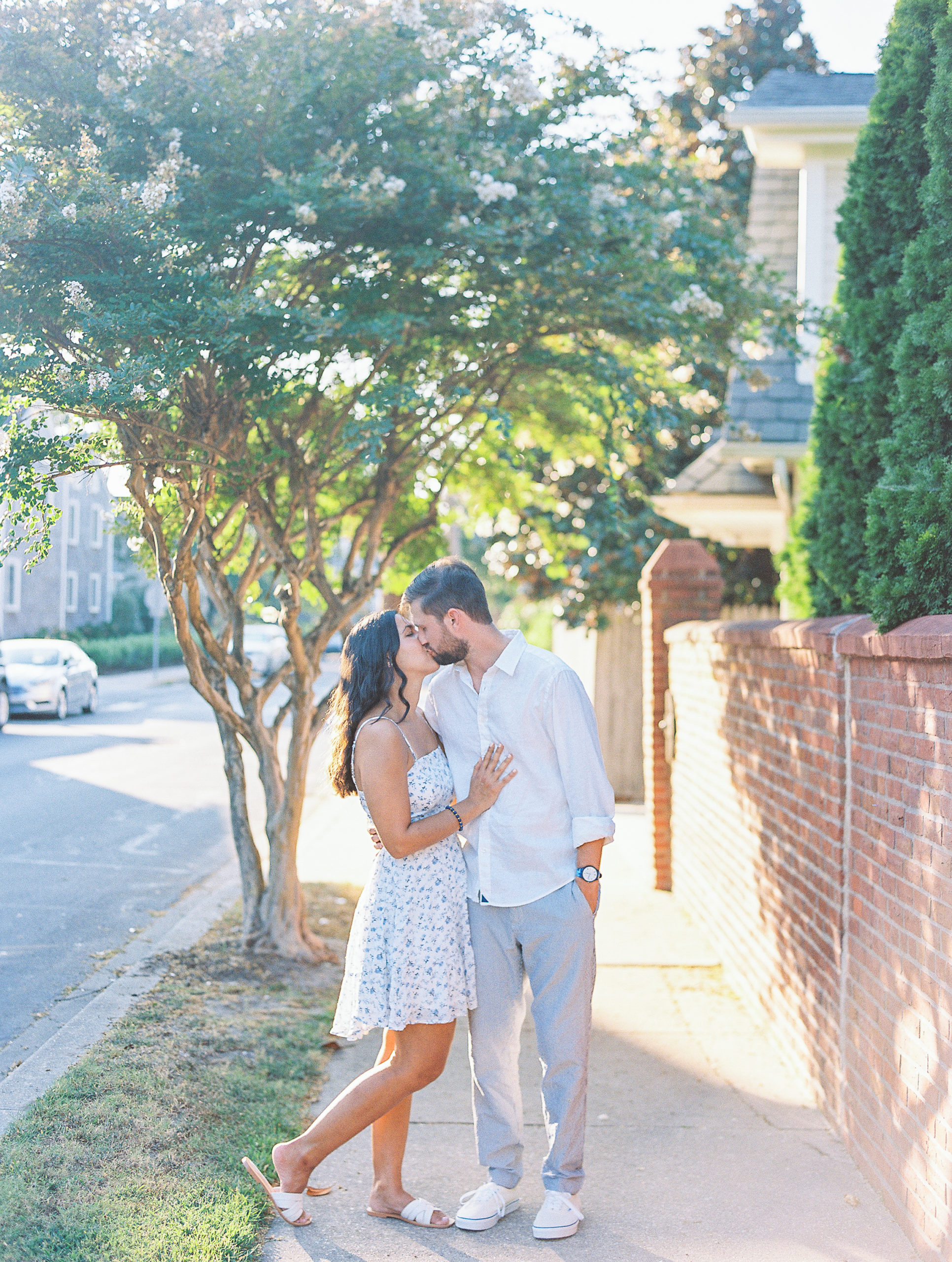 Couple kiss on the sidewalk for Summer Lewes Engagement Session
