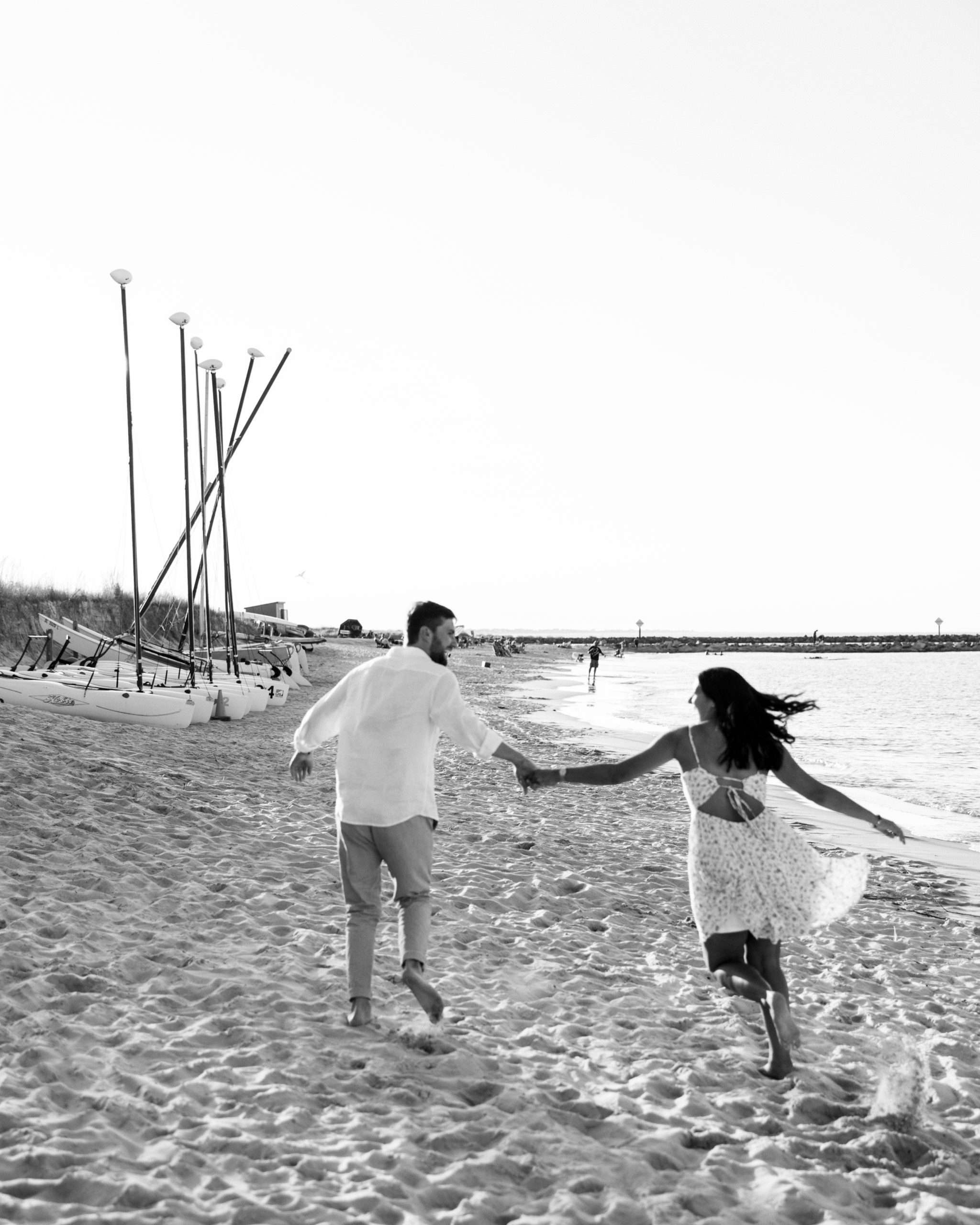 Couple run along the beach laughing and smiling for Summer Lewes Engagement Session
